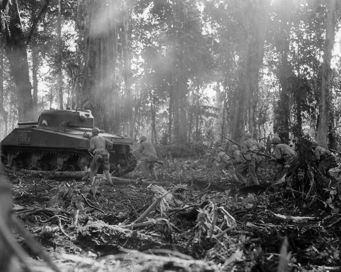 Troops from the US 129th Infantry Regiment advance with an M4 tank on Bougainville, 16 March 1944, during the Japanese counterattack on the US lodgement around Torokina