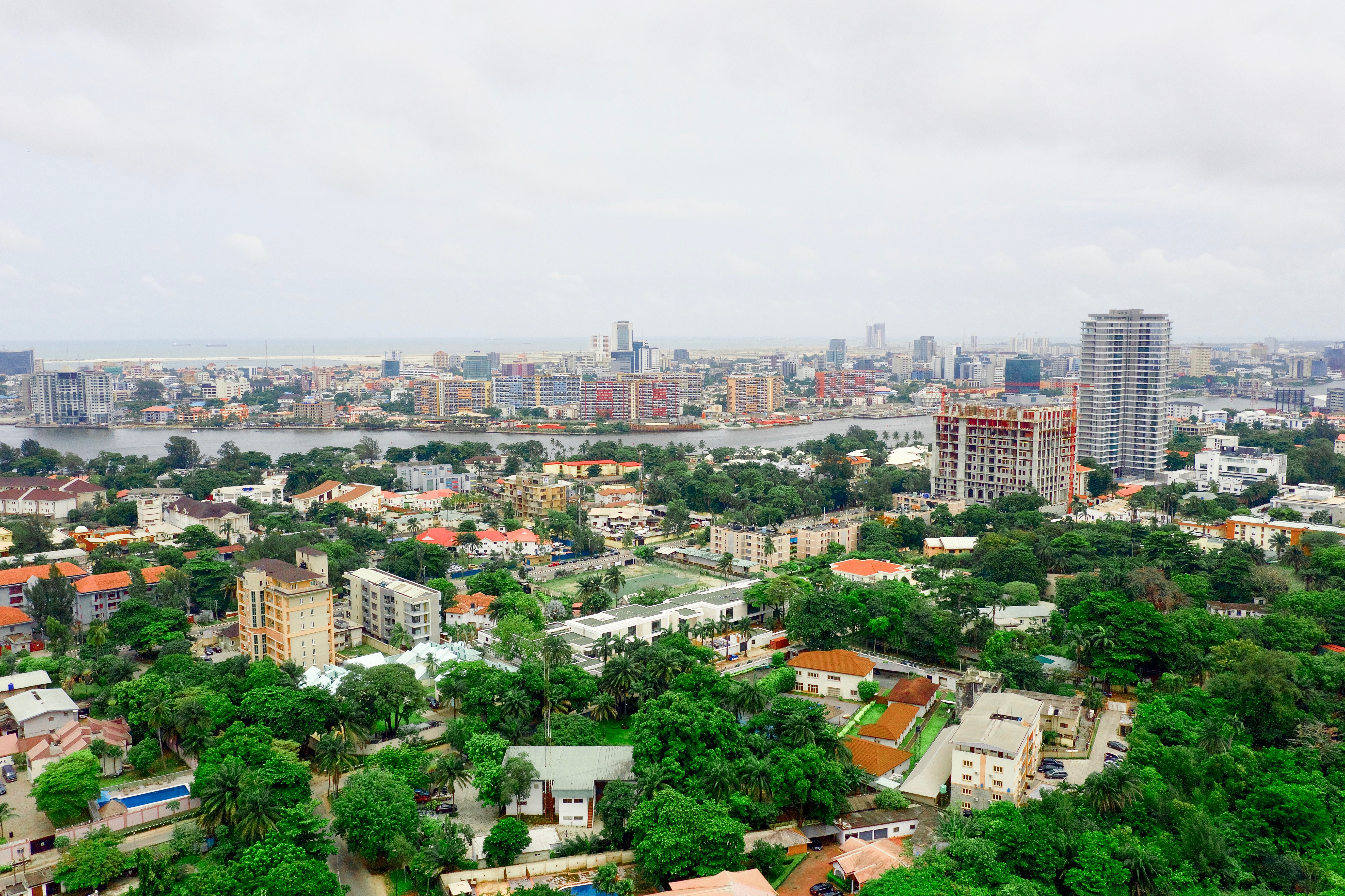 This is an aerial shot using the DJI Mavic Pro 2 drone. The area is a part of Ikoyi, an upper-class suburb of the sprawling megacity called Lagos, in Nigeria. Beyond the Lagoon is Victoria Island, and beyond that is the new city being built and called Eko Atlantic City, right by the Atlantic Ocean.