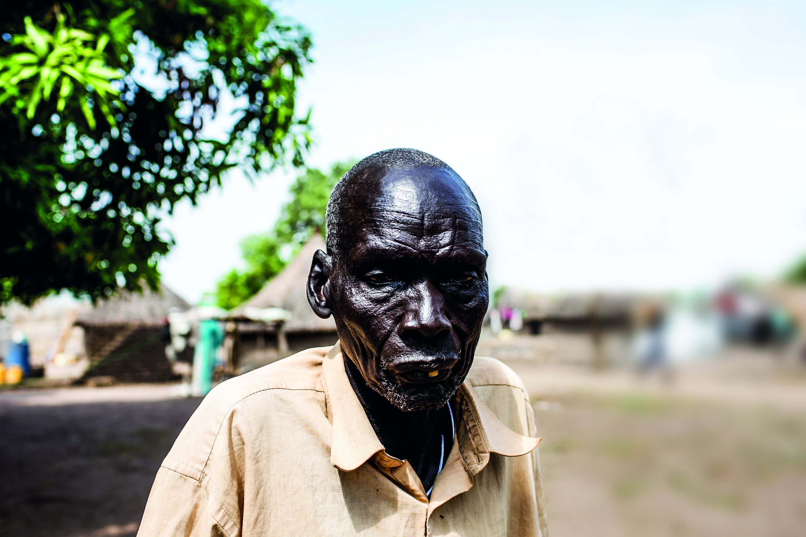I have lived many years and know how we lived before all the wars. We were cattle keepers and could move freely grazing our bulls. Yes, there were clashes and fights like in every society, but they were small and could be resolved with time and reason. There were traditional systems that worked. We were free to travel and see different lands, meet new people and share our experiences, all the while trading in cattle and making money. This has not been the reality for a long time.  
I was in Bor with my family when the fighting broke out. I told them to run because I am old and disabled. I lost my leg during the first war. I was left alone and on the first day, men walked into my house. They were Nuer. One of them saw me and wanted to kill me but his friend stopped him in his tracks.
He looked at the young man and asked, ‘Look at this man. If you kill him, what will you accomplish? This man has done nothing wrong to you and yet you want to kill him. What will you gain from doing that?’
The young man lowered his gun and left the house. I don’t know the name of the man who saved my life but I am very grateful for what he did. Before he left, he looked at me and said, ‘Stay here and don’t make any noise. I will lock the door behind me. Do not open it for anyone else.’
That man saved my life. I wish I knew his name and where to find him so that I can thank him again.
‘He gives me hope that there is still room for healing despite all wounds we have endured.
There is still hope if our systems transform towards reconciliation and healing.’

Photo: Mackenzie Knowles Coursin/Oxfam