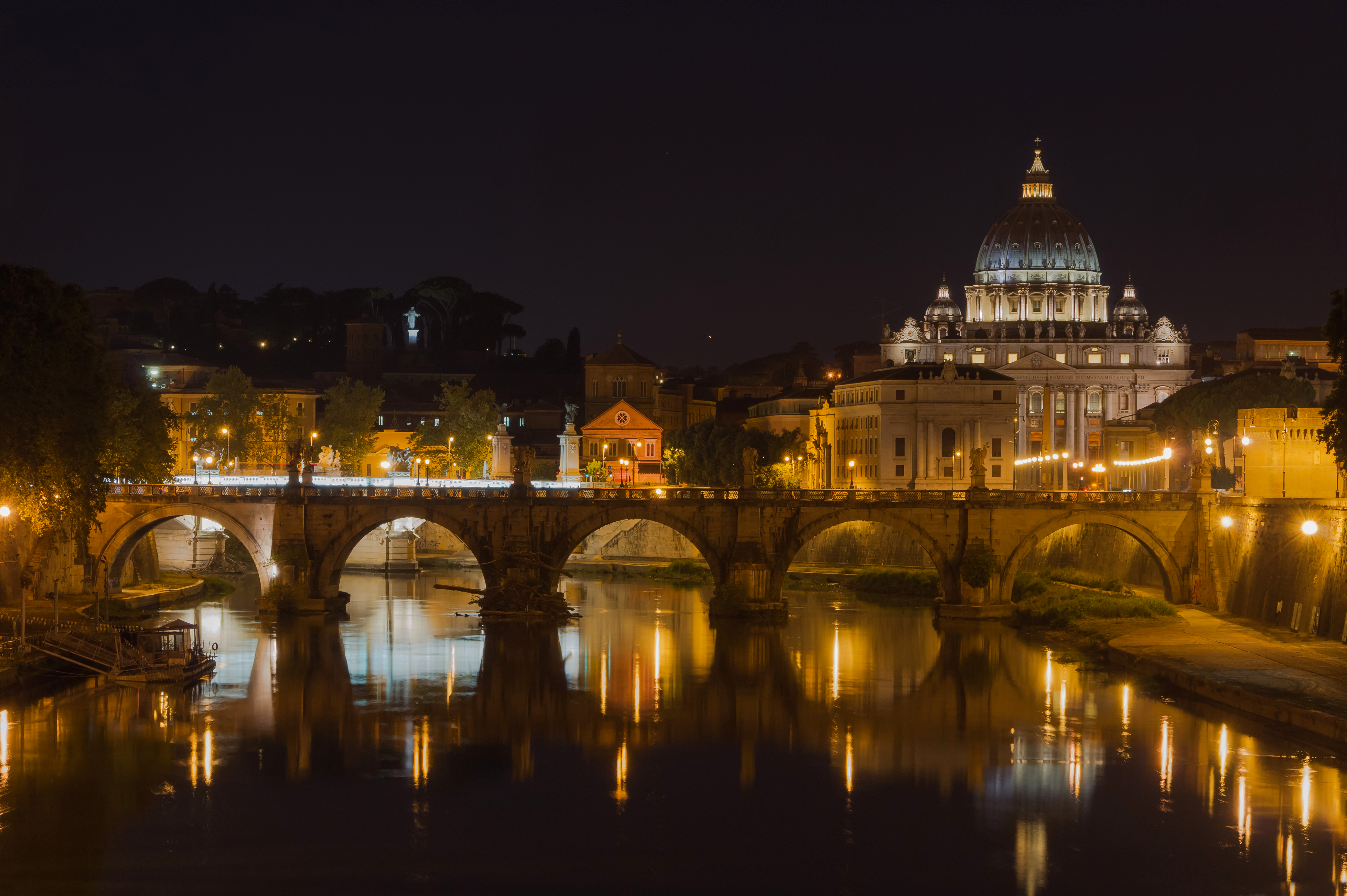 Saint Angelo Bridge over the Tiber River with the St. Peter's Basilica in the background from the Umberto I Bridge, Rome, Italy.