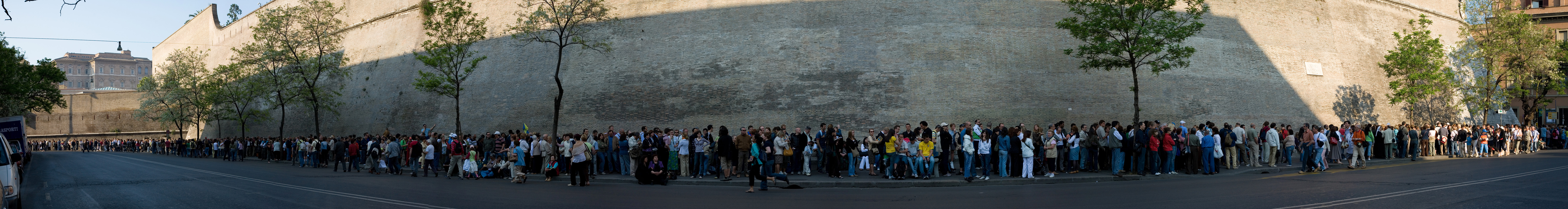 On the last Sunday of each month, the Vatican Museum is open to the public at no charge. This is extremely popular and it is not uncommon to wait in line for many hours. The other days of week you can use the on-line ticket office. This image is a panoramic view of one small stretch of the entire queue, which continued for some distance in both directions beyond view. Taken by myself with a Canon 5D and 24-105mm f/4L IS lens.
