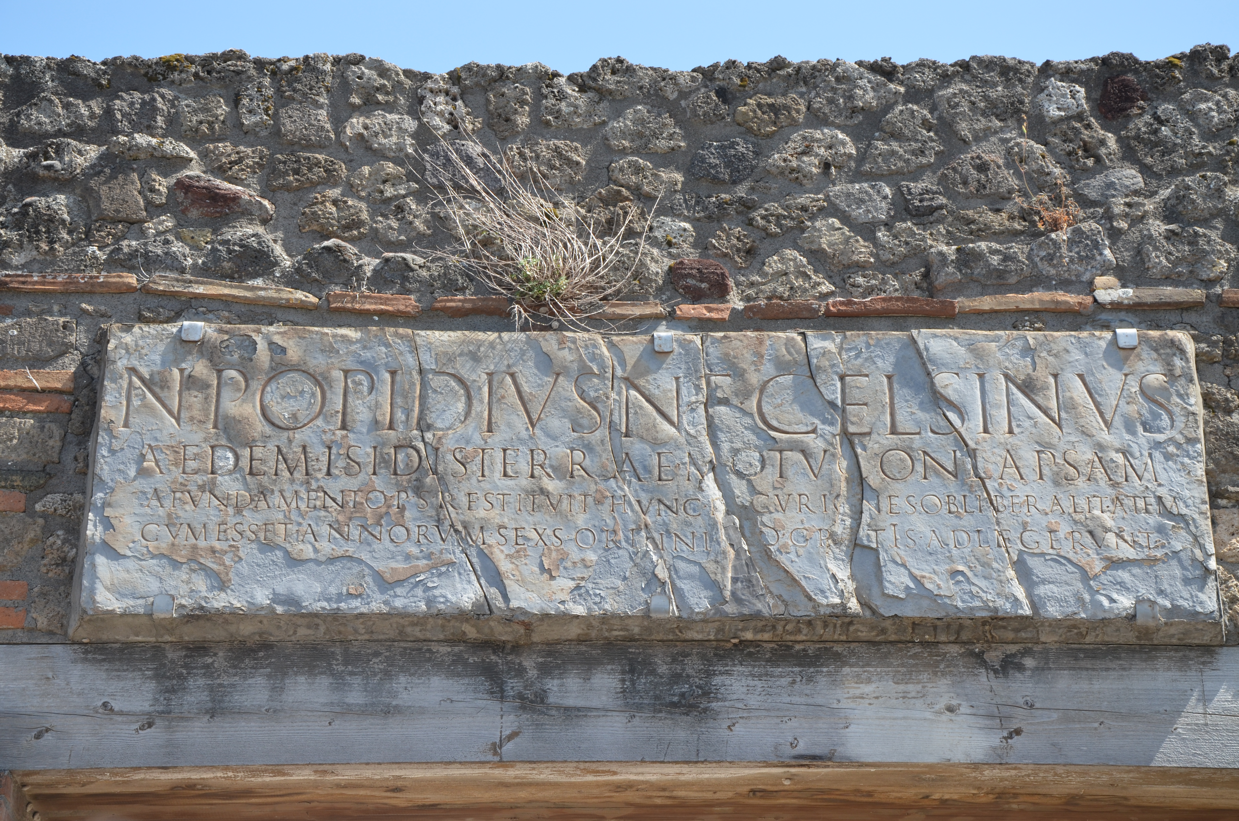 Pompeii, Temple of Isis - copy of dedicatory inscription to the temple reconstruction after the earthquake of AD 62, financed by the freedman Numerius Popidius Ampliatus in the name of his son Celsinus.
