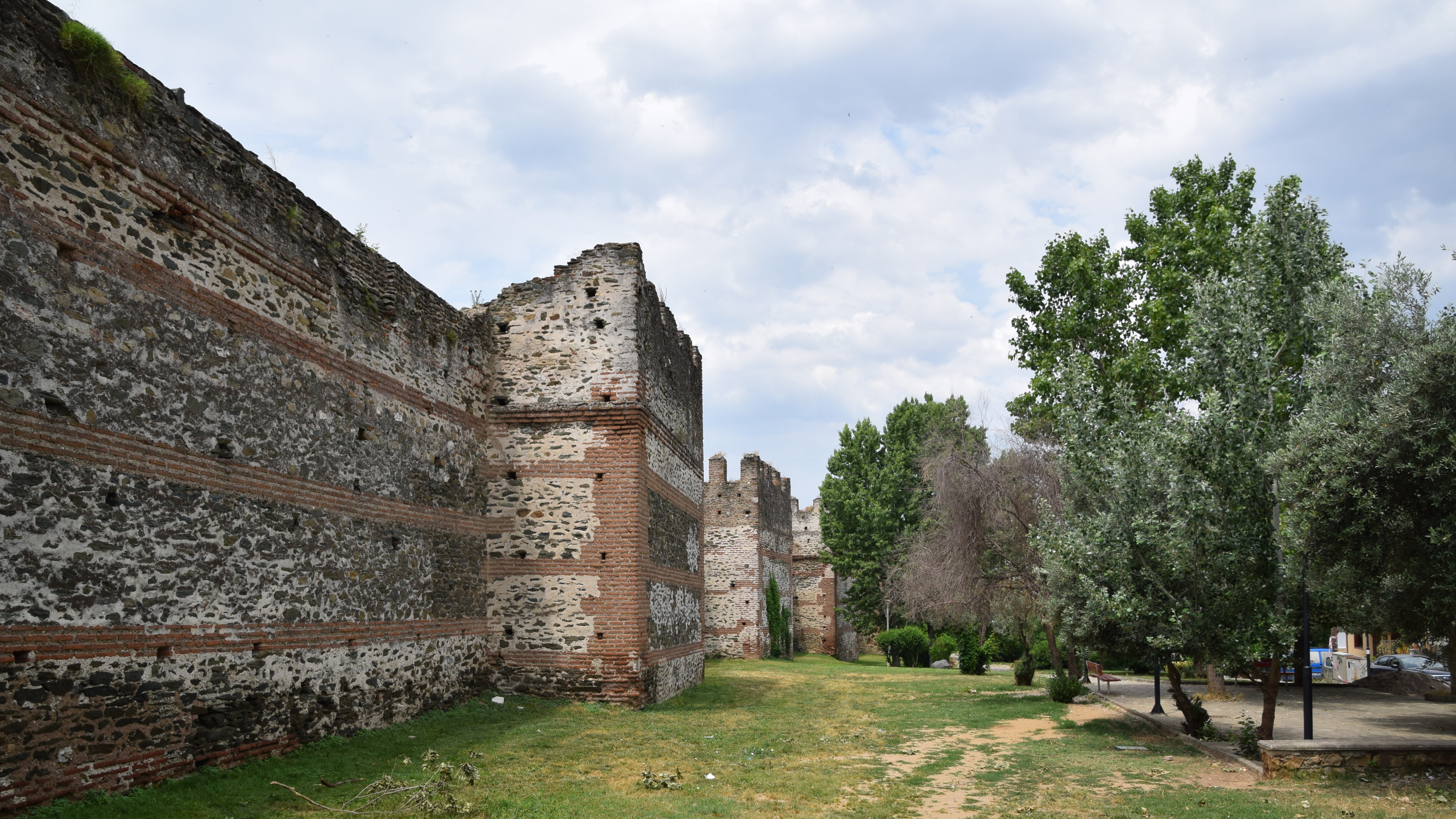 Fortified wall with at intervals towers and gates.The Walls were between 10 and 12 metres high, consisting of stone blocks held together with sand based mortar and incorporating pieces of marble from ancient monuments in the city.