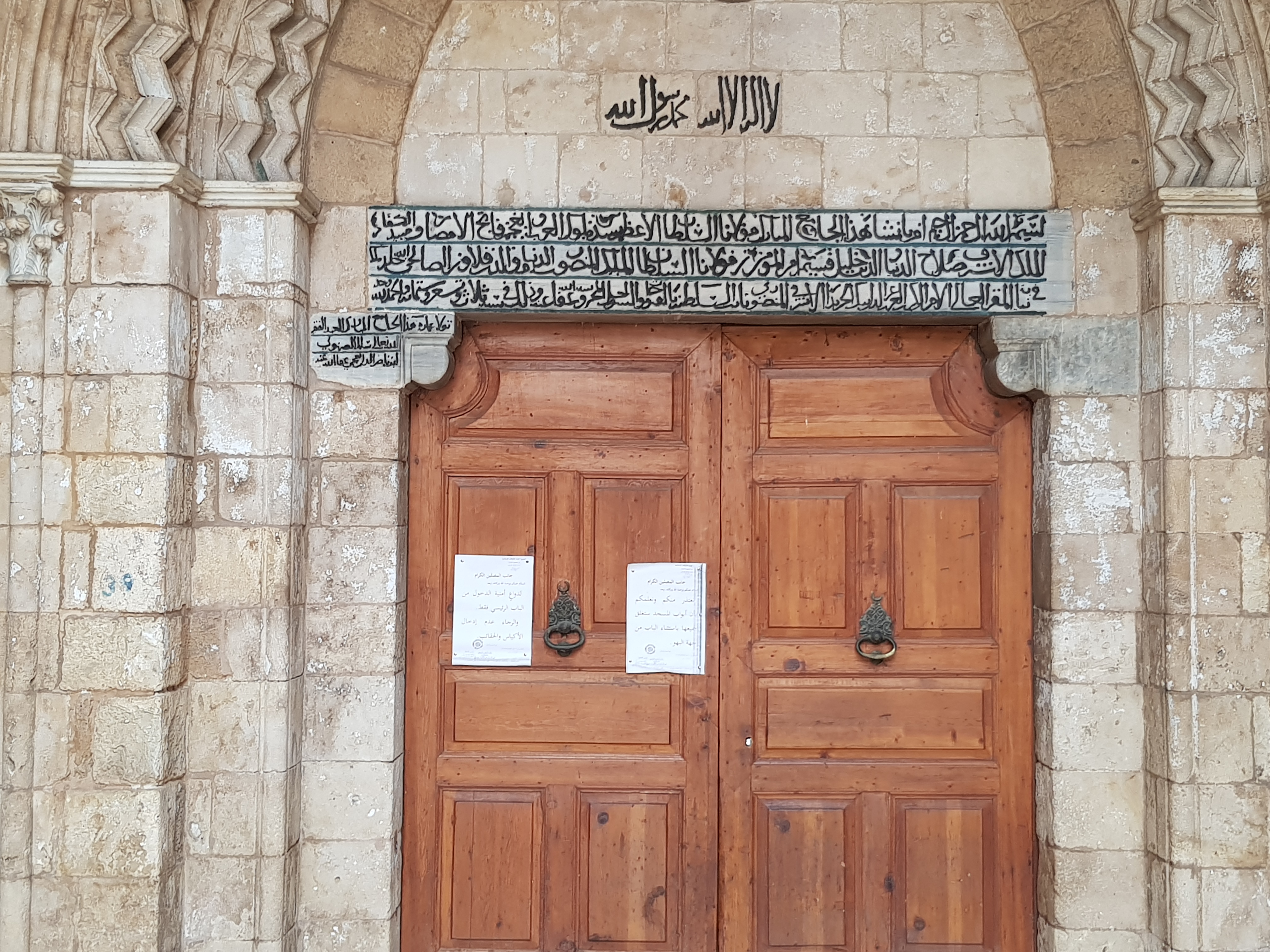 نقشٌ على مدخل الجامع المنصوري الكبير في طرابُلس الشَّام. النص هو: 
لا إله إلا الله مُحمَّد رسول الله

بسم الله الرحمن الرحيم. أمر بإنشاء هذا الجامع المُبارك مولانا السُلطان الأعظم أسد مُلُوك العرب والعجم فاتح الأمصار ومُبيد الكُفَّار الملك الأشرف صلاح الدين خليل قسيم أمر المؤمنين مولانا السُلطان الملك المنصور في الدنيا قلاوون الصالحي خلَّد الله مُلكه. في نيابة المقر العالي الأمر الكبير أيبك الحريد الأشرفي المنصوري نائب السلطنة بالفُتُوحات والسواحل المحروسة عفا الله عنه وذلك في سنة ثلاث وتسعة وستمائة والحمد لله وحده. تولَّا عمارة هذا الجامع المُبارك العبد الفقير لله تعالى سلام الصهنولي ابن ناصر الدين العجمي عفا الله عنه.