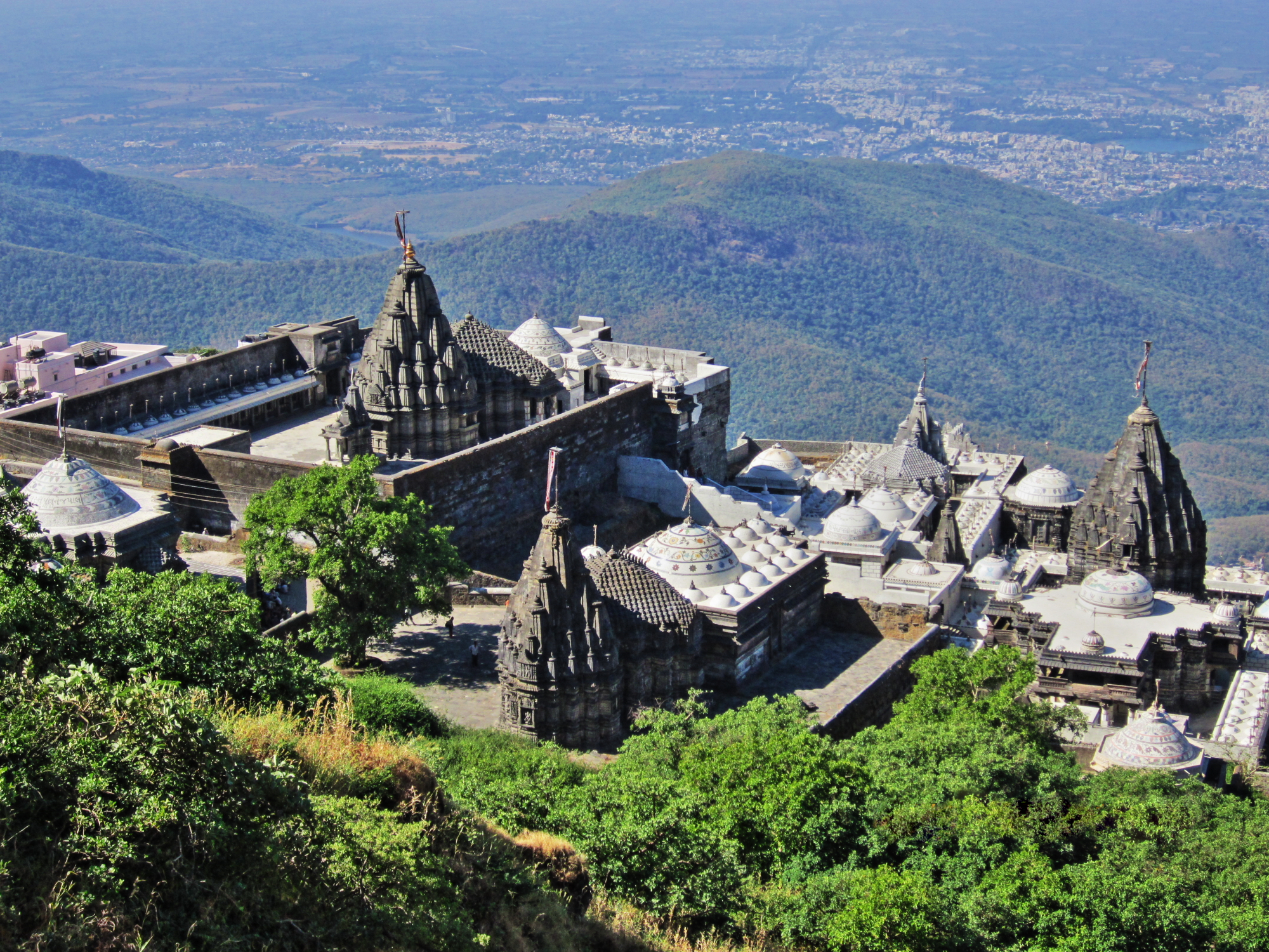 Girnar mountain is highest mountain of Gujarat state, India. On the mountain there are so many temples of Hindu and Jain religion. Some of them are in this photo. Photo is captured from much above than these temples during summit of Girnar mountain. In this photo main Jain temple on Girnar mountain - Neminath Derasar is also featured.