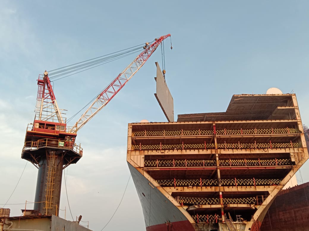 Removing steel plates from ship using cranes in Ship recycling yard in Alang