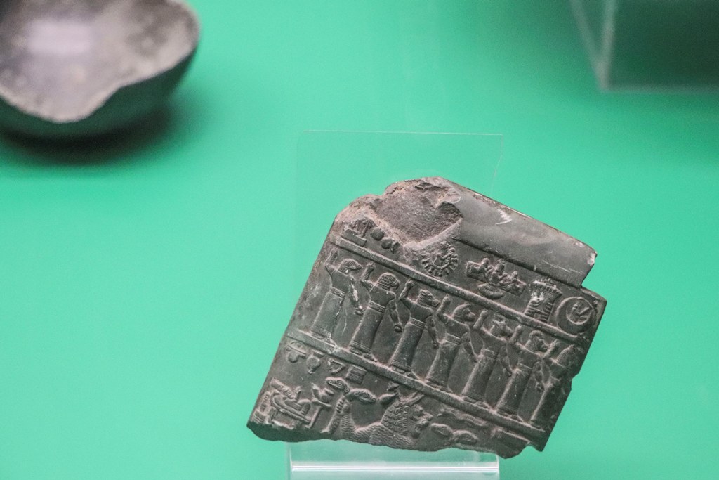 Basrah Museum, Assyrian Gallery: Stone Lamashtu plaque. Caved with symbols of gods and row of demons, the plaque was intended frighten away the demoness Lamashtu, shown in the lower register with a lion's head and grasping two-headed snakes. Neo-Assyrian period (911-612 BCE).