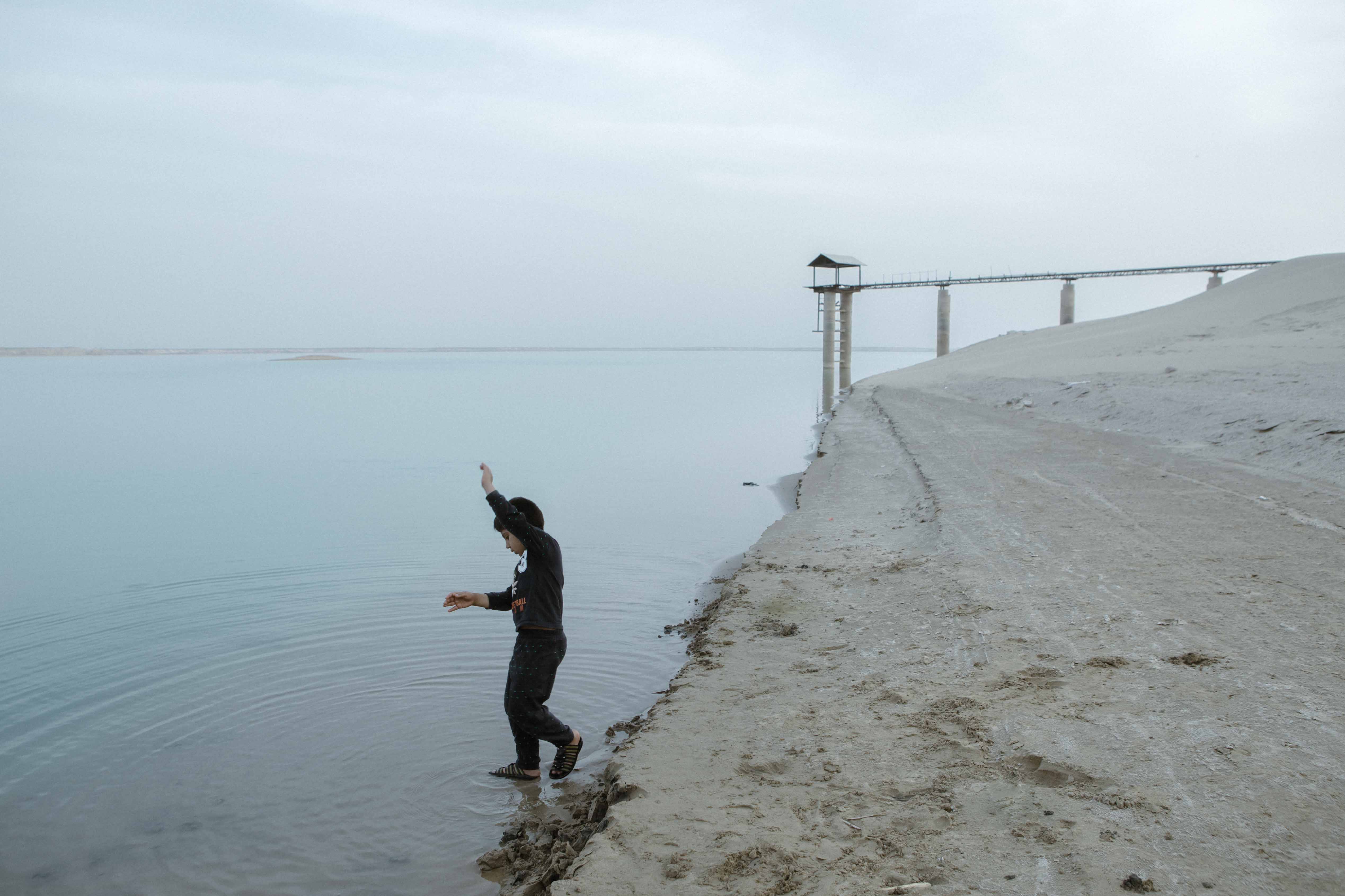 Children are playing around the Chah Nimeh reservoirs. The Chah Nimeh reservoirs are large natural holes in Sistan province into which Hirmand river water is directed. In times of water shortage, Sistan’s drinking water and some part of its farming water are provided through this artificial lake. The only sign of water in the Sistan landscape is the Chah Nimeh reservoir.
During 20 years, the Hamoun wetlands had vanished after the South Asia region was hit by the most persistent drought. Besides building many dams at the Upstream Hirmand, Afghanistan refuses to adapt to Iran’s water rights and violates its water agreements. Sistan province.2018