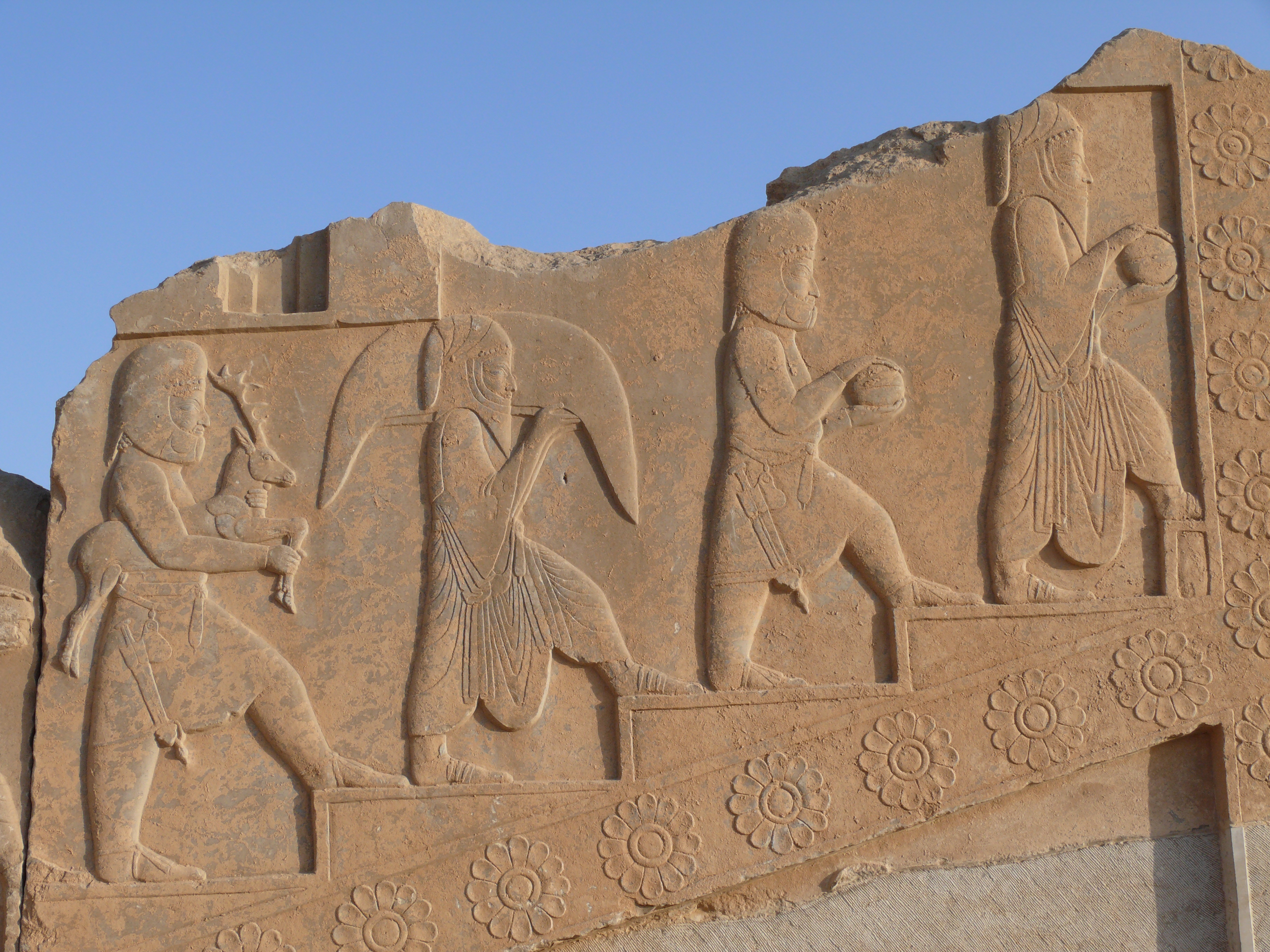 Priests procession at Persepolis. This relief is one of a group of several showing the same kind of procession scene. it decorates the Tachara, Darius the Great's private palace at Persepolis, Iran. According to Werner Dutz, it shows Median and Arachosian priests carrying various gifts and animals for a ritual of sacrifice. During Achaemenian time, Zoroastrism was under a primary form, resulting in the main practice of Mazdeism. 2 Lakes were considered as holy: Hamun-e Orumyeh in Media (Now in Azarbaidjan-e Gharbi province), and Hamun-e Halmand in Arachosia (now at the border between Iran and Afghanistan). It could explain why are the priests medians and Arachosians, identified with their clothings and hats. 
But controversies also exist, and some scholars do not think the relief shows priests, but servants at to the royal court bringing the necessary for the royal dinners. Achaemenian dinners were very important political ceremonies, and the possibility exist that this reliefs was made to remind the magnifiscence of these dinners where very few priivileged nobles were invited according to the king's will or agenda.

Taken in Persepolis, City of Marvdasht, Province of Fars, Iran, April 2008.
