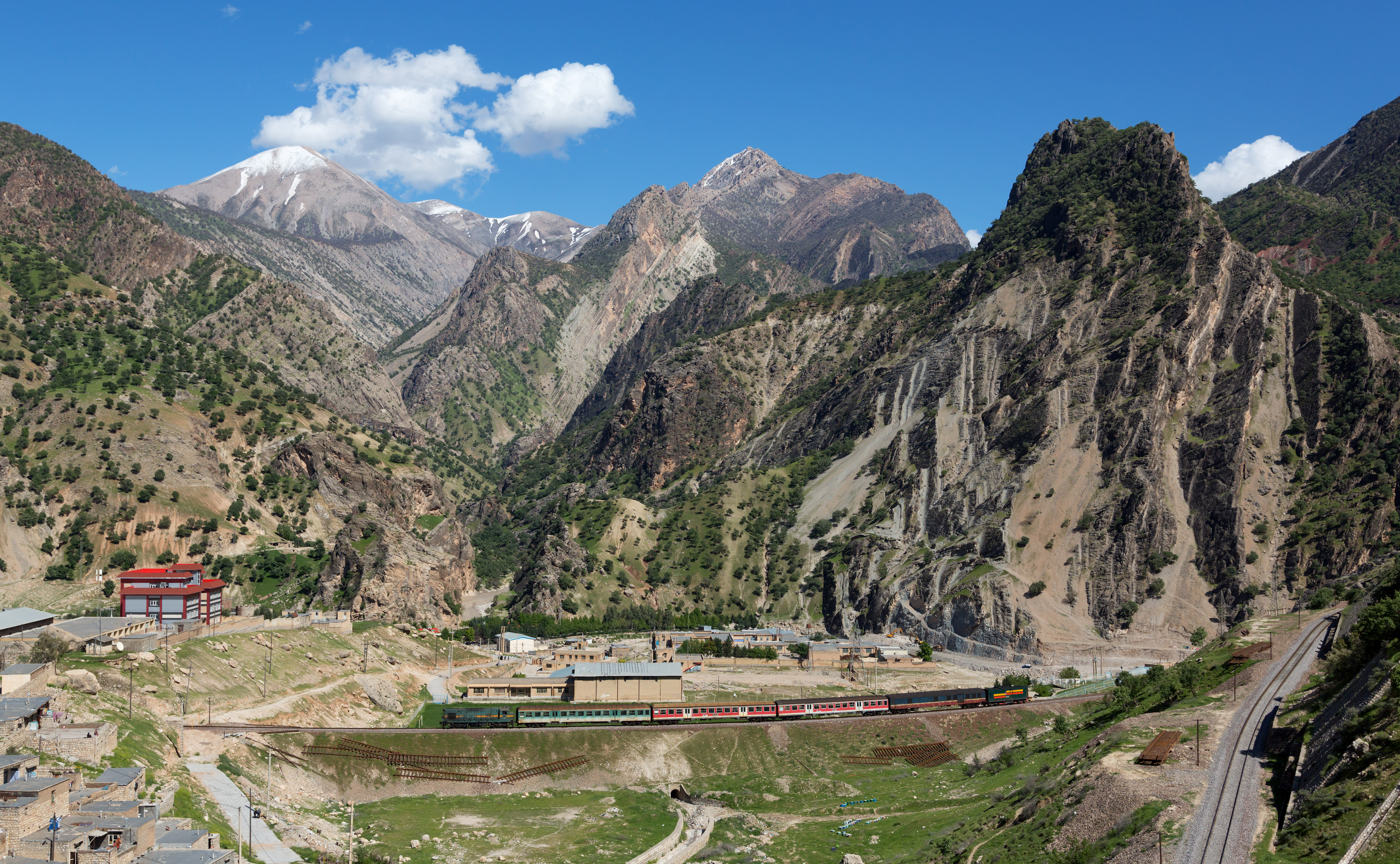 40-12 (EMD G12) of Islamic Republic of Iran Railways hauls a local train from Chamsangar to Dorud. The train consists of former DB Regio "Silberlinge" passenger cars, a baggage car of unknown origin and a US-style boxcar fitted with a diesel generator. Pictured just before entering the loops of Sepid Dasht, Iran.