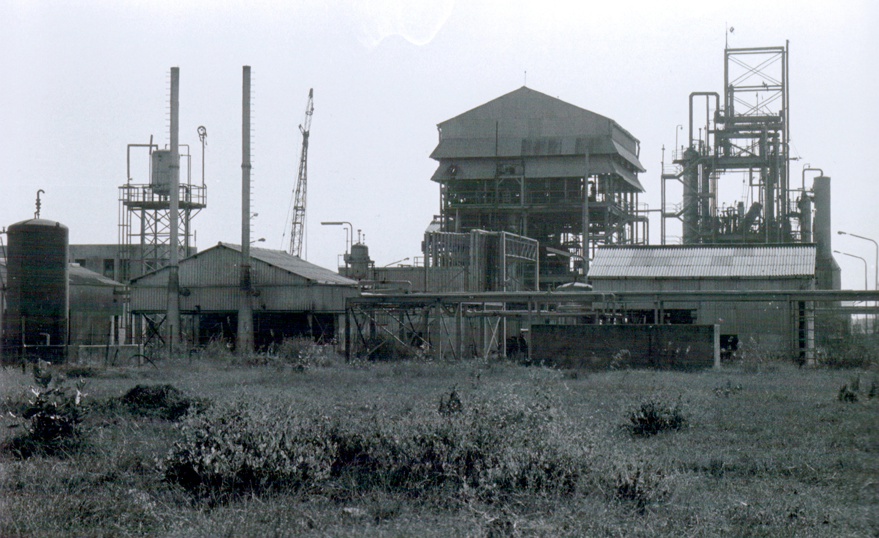 Exterior view of the Union Carbide pesticide factory in Bhopal, India, scene of the world's worst industrial disaster in 1985.
Interior shot of the factory before it was stripped of some of its most valuable components and subsequently abandoned to the elements.
The factory remains ruined and abandoned and approximately 350 metric tonnes of toxic waste are stored there above ground.
Many thousands of tonnes of toxic waste were also buried, in an untreated state, on the site.
Rainwater continues to run through this buried waste as well as the remains of the abandoned solar evaporation ponds.

This leaches toxic chemicals into the local groundwater aquifer, which serves as the primary water supply for thousands of people.