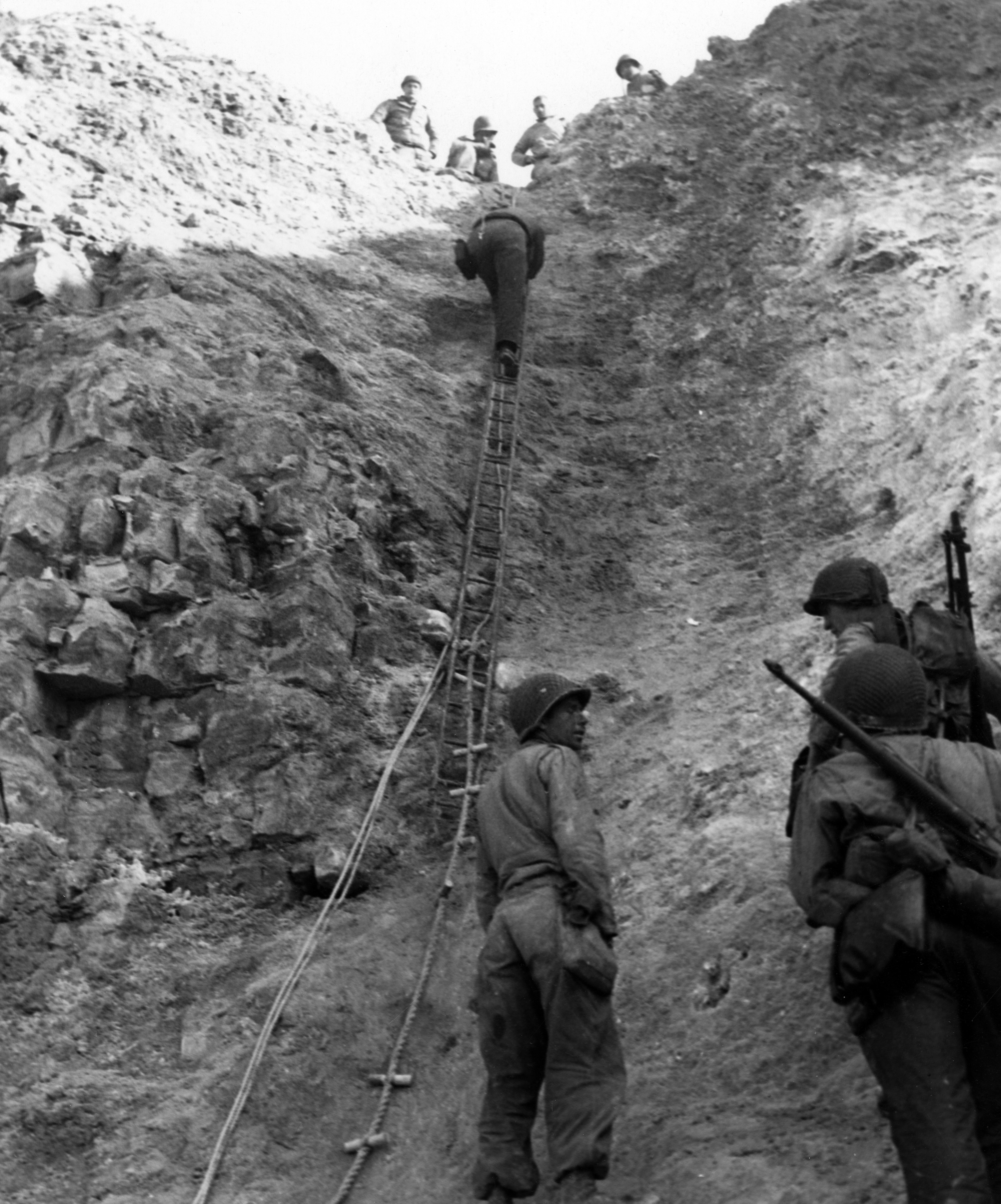 Normandy Invasion, June 1944 U.S. Army Rangers show off the ladders they used to storm the cliffs at Pointe du Hoc, which they assaulted in support of "Omaha" Beach landings on "D-Day". Removed caption read: Photo #80-G-45716  Army Rangers at Pointe du Hoc, 6 June 1944