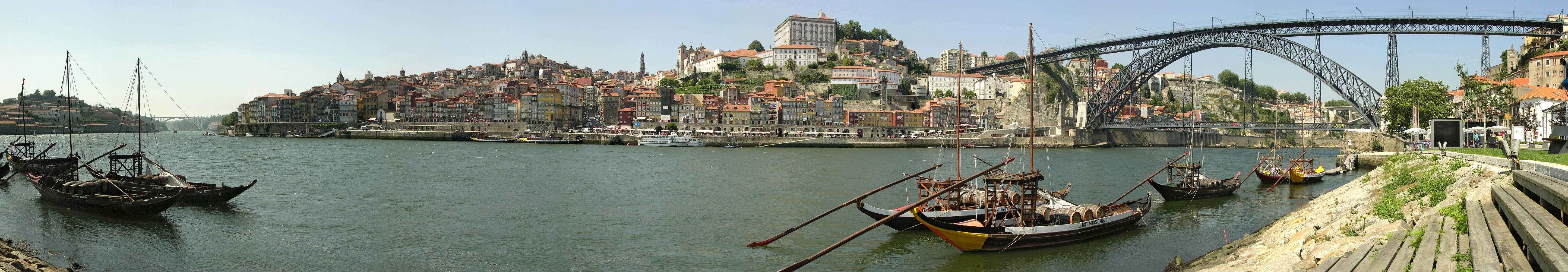 Historical part of Porto, a World Heritage Site seen from Vila Nova de Gaia, trough the Douro river.
At the right, the metallic Luiz I (Dom Luís Bridge) with the northern tip of the Infante bridge behind it. At its left, the whole historic center with the Clérigos Tower in the horizon. The plaza in the middle is the Ribeira plaza. In the leftmost part of the picture, the Arrábida bridge. The picture also shows the typical rabelo boats, once used for the transport of Port wine.