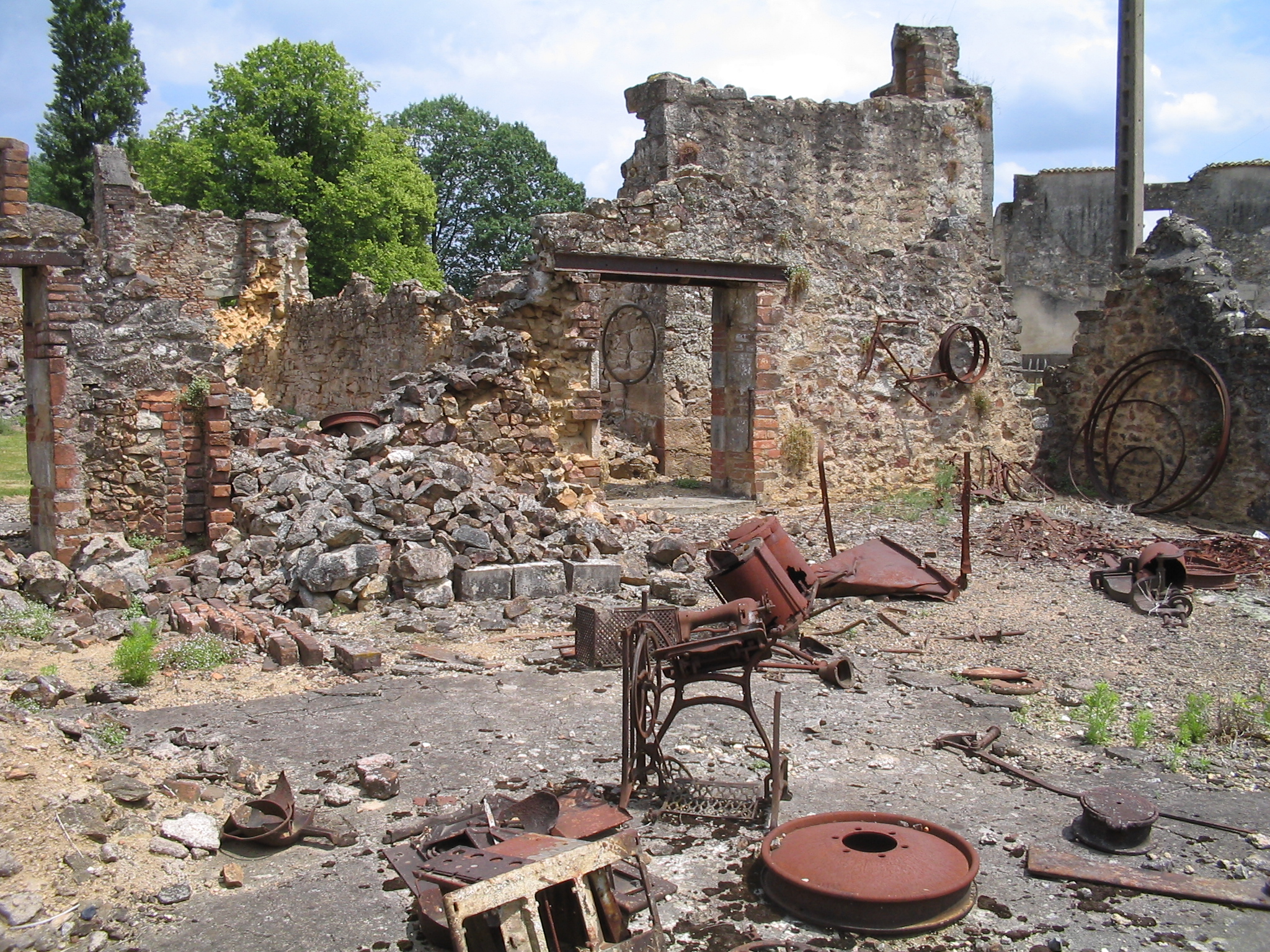 Wrecked hardware (bicycles, a sewing machine etc.) in Oradour-sur Glane.

Photograph taken in Oradour-sur-Glane 11 June 2004, exactly 60 years after its destruction by the German military.