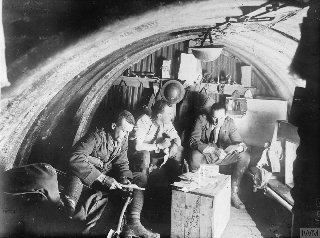 IWM caption : "THE THIRD BATTLE OF YPRES (PASSCHENDAELE) 31 JULY - 10 NOVEMBER 1917.
Interior of a dugout occupied by officers of the 105th Howitzer battery of the 4th Brigade. Three officers are looking at papers in the light of two candles on an upturned box".

Comment : This refers to the Australian 105th Howitzer Battery, part of the Australian 5th Field Artillery Brigade, attached to the Australian 2nd Division.