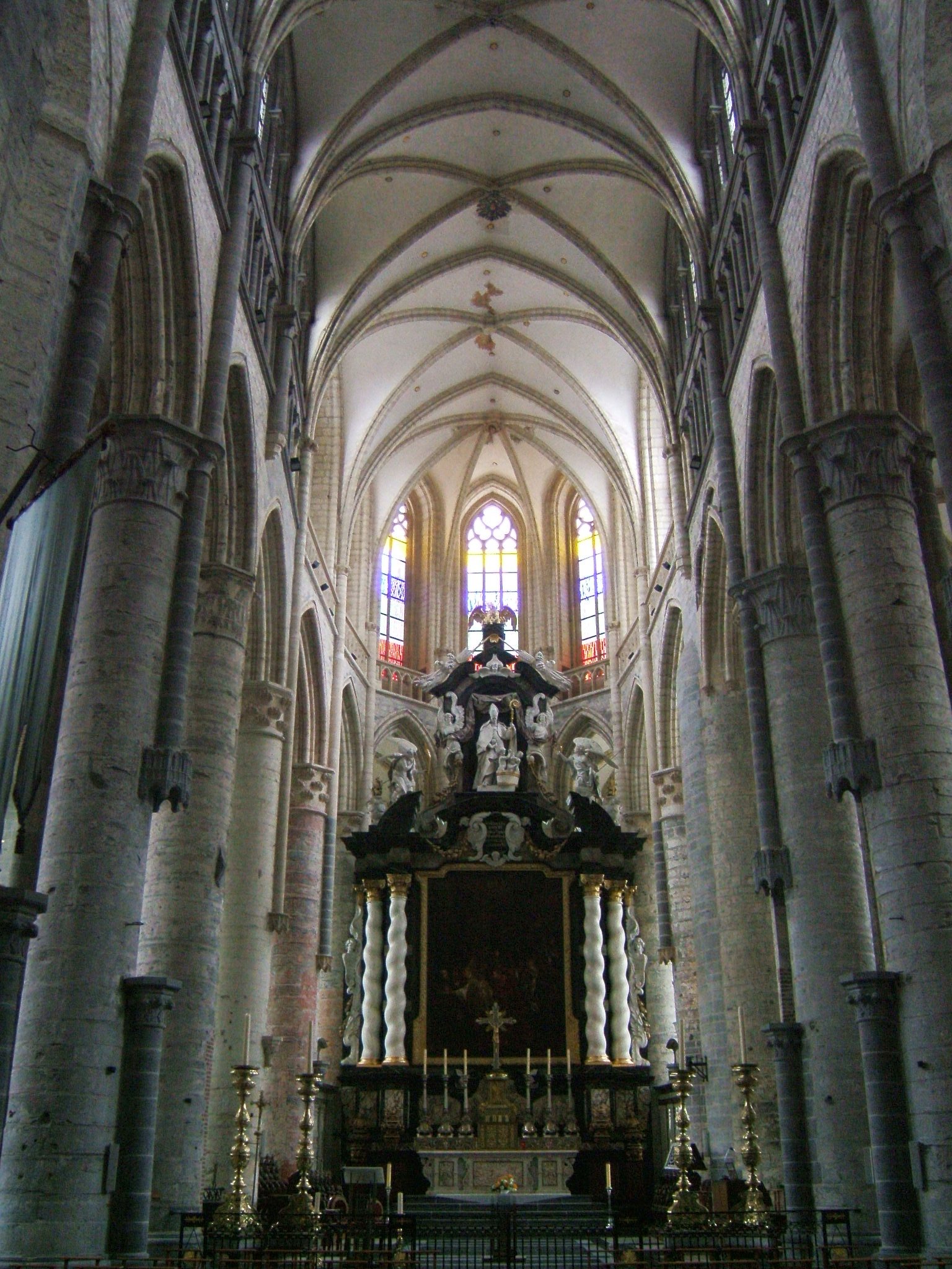 The main nave of the egothic Sint-Niklaaskerk in Gent. In the higher part of the altarpiece, there is a statue of Nicholas, the patron of the church.