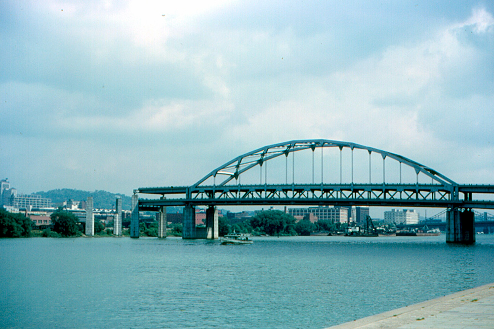 Pittsburgh had a real "Bridge to Nowhere."  The main span of the Fort Duquesne Bridge over the Allegheny River was completed in 1963.  Land for the approaches had not been acquired, so the bridge stayed like this for five years.  

The bridge was finally completed in 1968.  It now carries Interstate Highway I-279.  There are two decks of traffic.