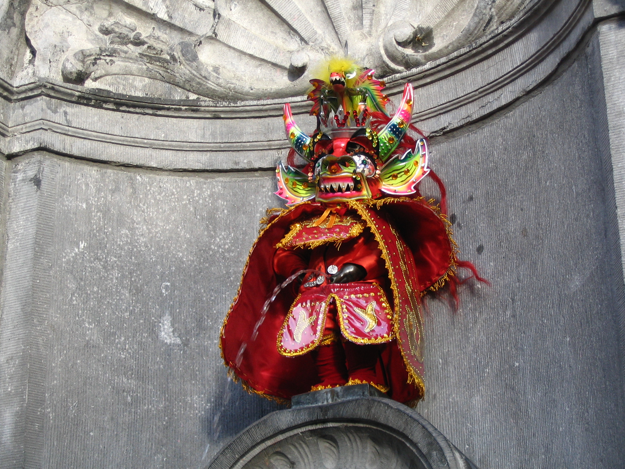 Photo du Manneken Pis (Bruxelles, Belgique) habillé avec le costume de la Diablada (danse folklorique de la Bolivie) pour rendre hommage au carnaval de Oruro (Bolivie), patrimoine orale et intangible de l'Unesco.