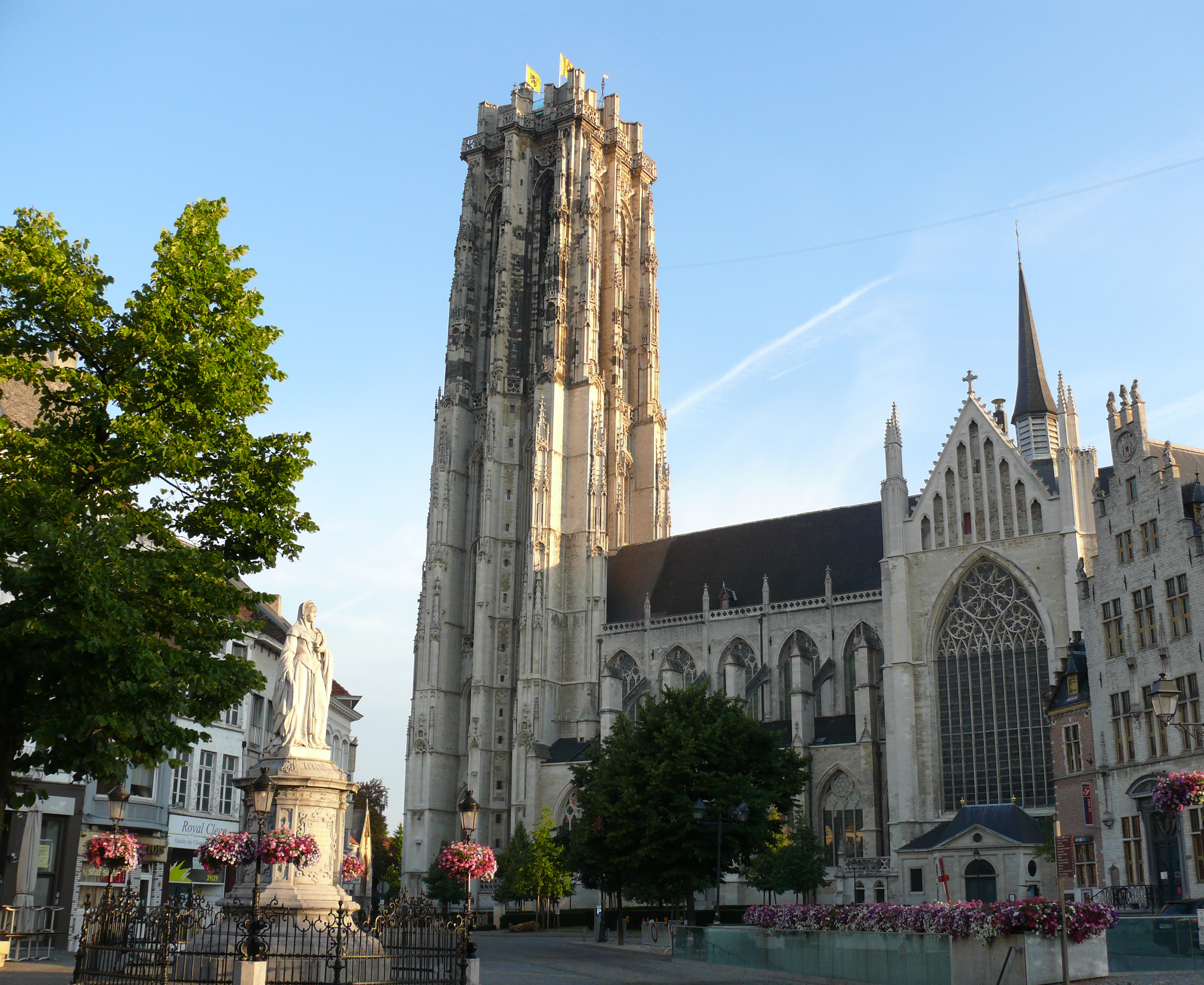 The flat-topped silhouette of the St-Rumbold's Cathedral's tower is easily recognizable and dominates the surroundings.  
Statue of Margaret of Austria, Duchess of Savoy on the Schoenmarkt in Mechelen.