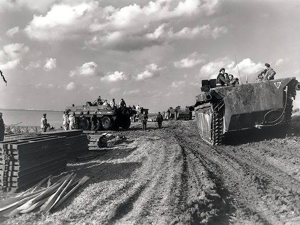A column of 'Alligator' amphibious vehicles passing Terrepin amphibious vehicles on the Scheldt River near Terneuzen, October 13th, 1944