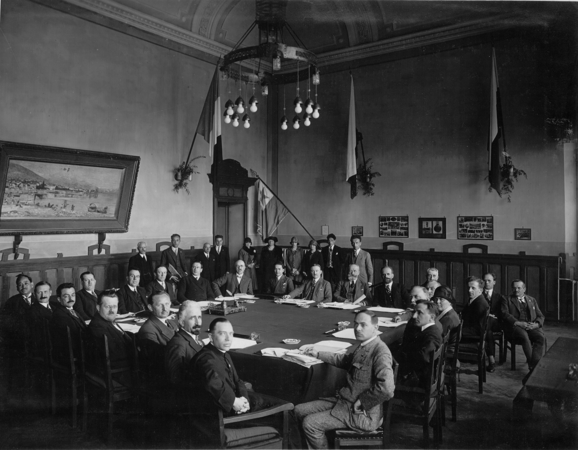 Meeting of Internacia Centra Komitato and Konstanta Reprezentantaro de la Naciaj Societoj (later: Universal Esperanto Association), Locarno (Switzerland), 1926. Front person, left: the priest Andreo Cseh. To his left, following the table: Carlo Gilá, Gustav Scholze, Rudolf Hromada, Frans Schoofs, Hugo Steiner, K. Nisximura, Robert Kreuz, Edmond Privat, Dr. Rusca (mayor of Locarno), Hans Jakob, G. Stroele, T. Morariu, A. Dubois, Johannes Dietterle, A. Stromboli, M. Rollet de l'Isle, Friedrich Ellersiek (nearly hidden), I. Rotkovicx (out of the row), Louis Bastien, Mrs. Blicher (?), Pál Balkányi (according to Enciklopedio de Esperanto, 1934, K/XVIII)