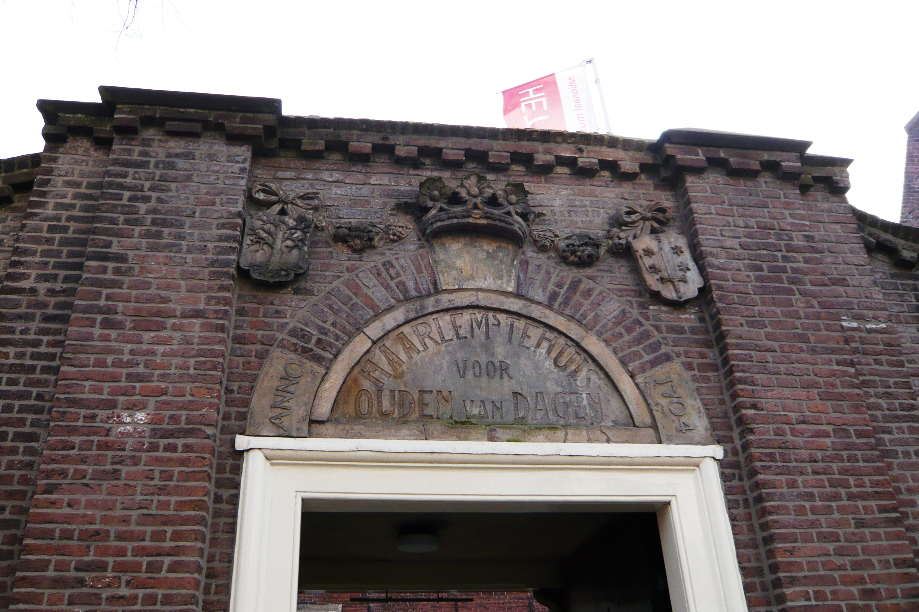 Keystone above the entrance of the museum 'Het Dolhuys' in Haarlem, the Netherlands. Originally a leper colony in the 14th century, it was a hospital for years until it was made into an old age home. Inscription states "Haarlems tehuis voor Ouden van Dagen, Anno 1704", meaning the old age home was founded in 1704. The Museum of Psychiatry is currently housed there and was founded in 2005. The old regent's room is currently undergoing restoration.