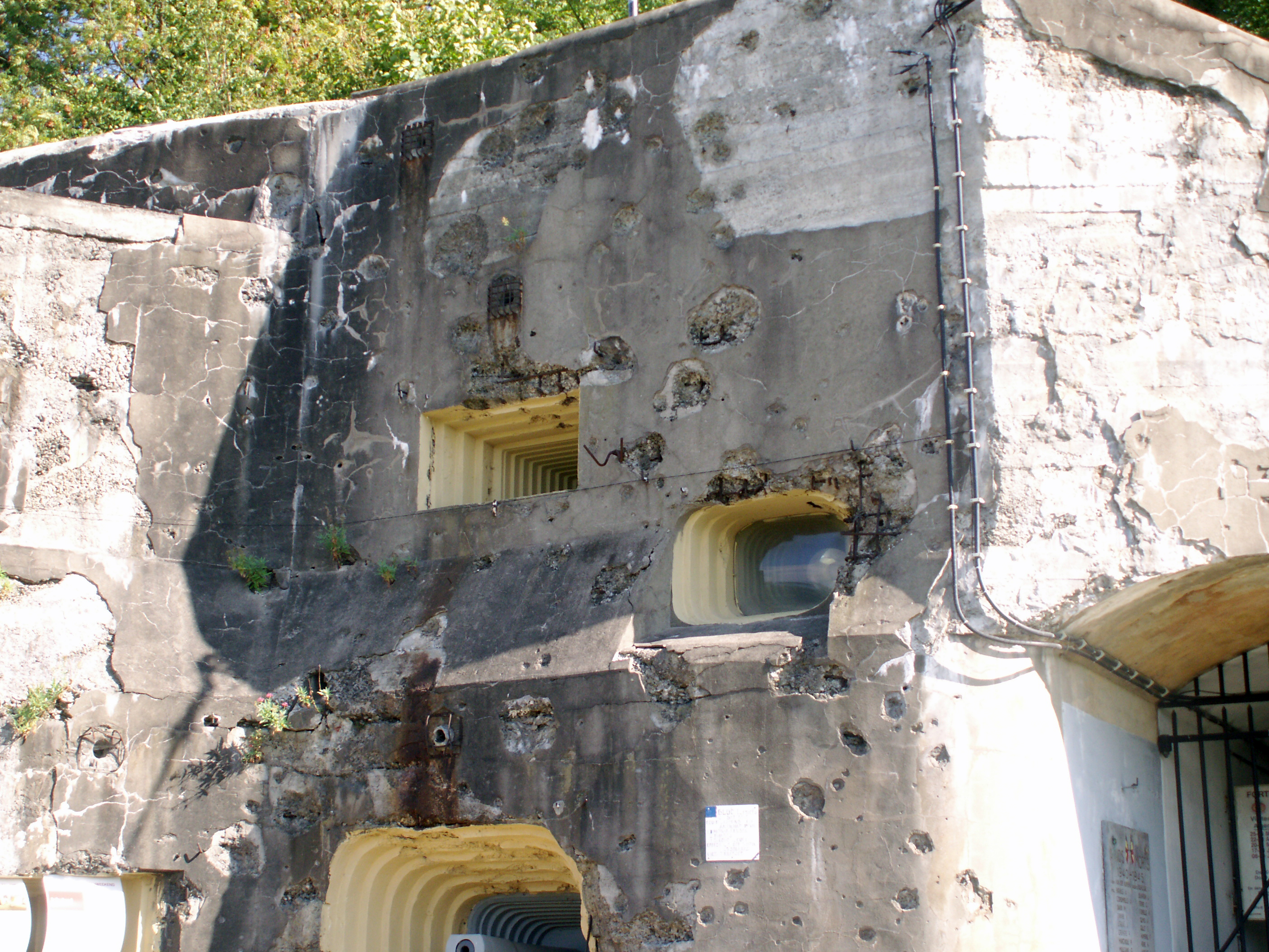 The parts of Fort Eben-Emael visible above ground level are scarred by
heavy fighting during World War II. The heavily fortified structure
(most of it below ground) was supposed to be unassailable, until a

German commando unit arrived from above by using glider planes.