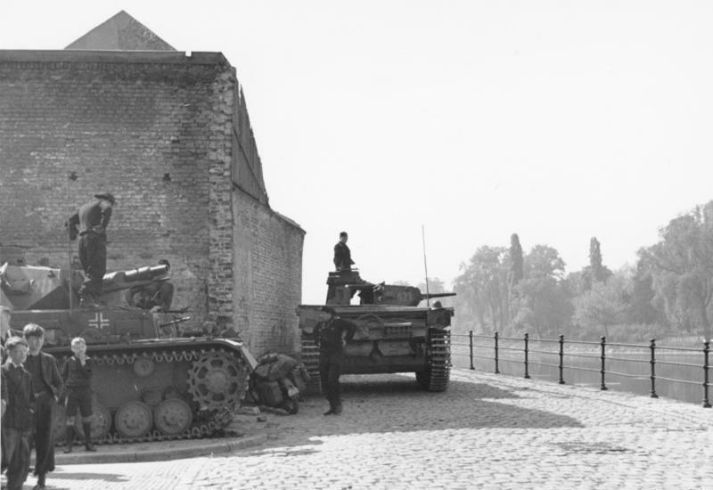 For documentary purposes the German Federal Archive often retained the original image captions, which may be erroneous, biased, obsolete or politically extreme. Maastricht. Deutsche Panzerkampfwagen als Sicherung an der Maas.
10. 5. 1940 vorm.
