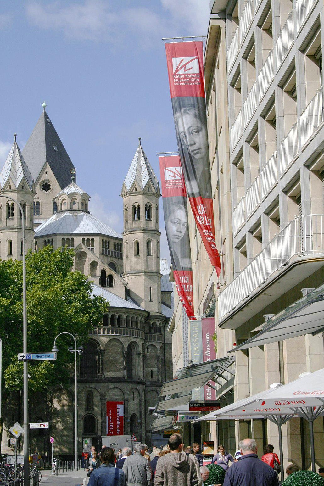 Fassade des Käthe Kollwitz Museum Köln mit Fahnen. Blick in Richtung St. Aposteln.