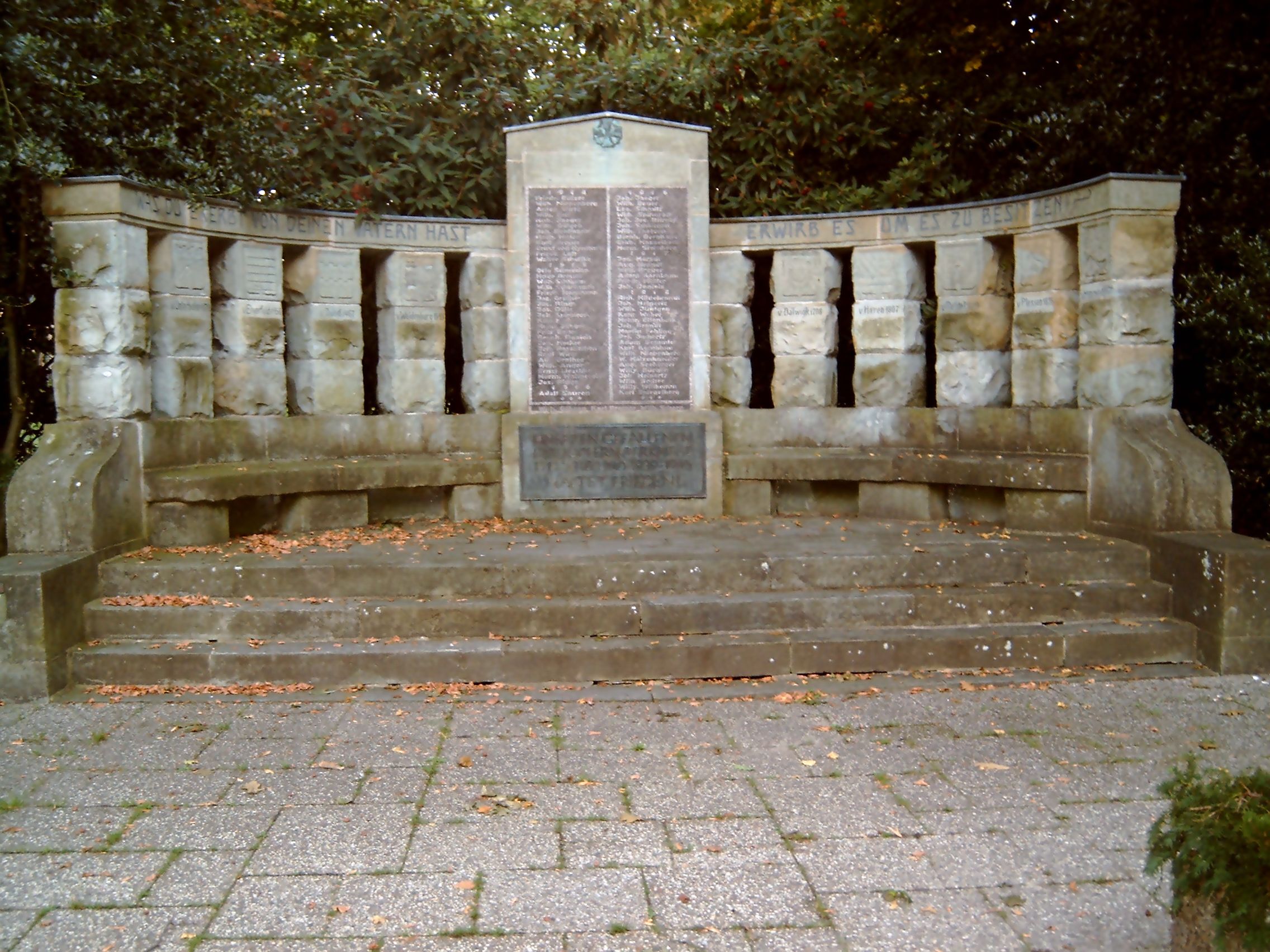 Unterbacher Denkmal vor dem Friedhof in Düsseldorf-Unterbach. Auf der Tafel in der Mitte werden die Namen der Gefallenen des 1. Weltkriegs genannt. Wappen und Namen der Herren von Haus Unterbach sind in die Pfeiler gemeißelt. 1913 eingeweiht war dies das Kaiser-Jubiläumsdenkmal. Damals auf der mittigen Tafel das Konterfei des Kaisers. Werk des Düsseldorfer Bildhauers Joseph Hammerschmidt.