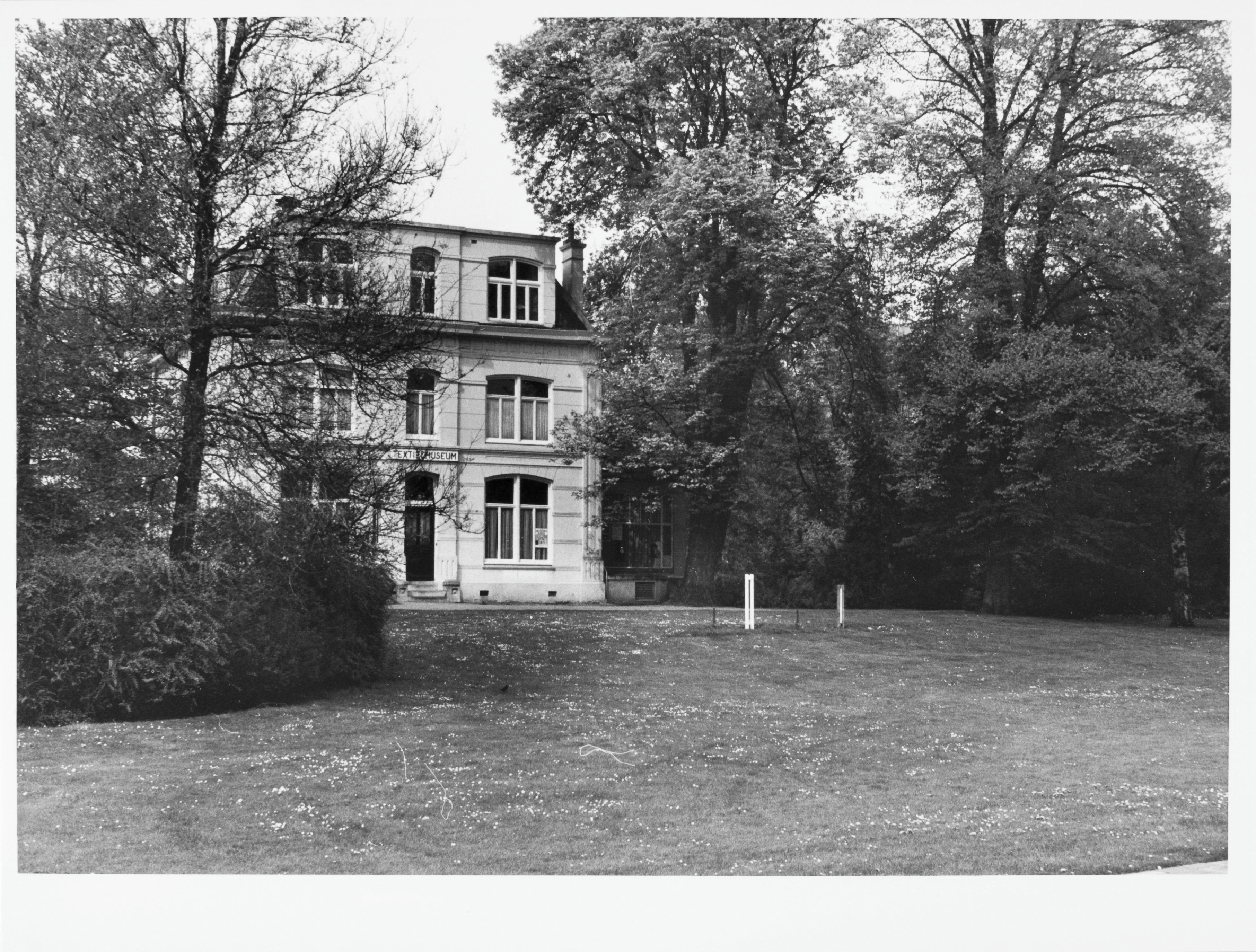 Enschede Villa Blijdenstein: Voorgevel tussen de bomen door gezien. Villa de Bank