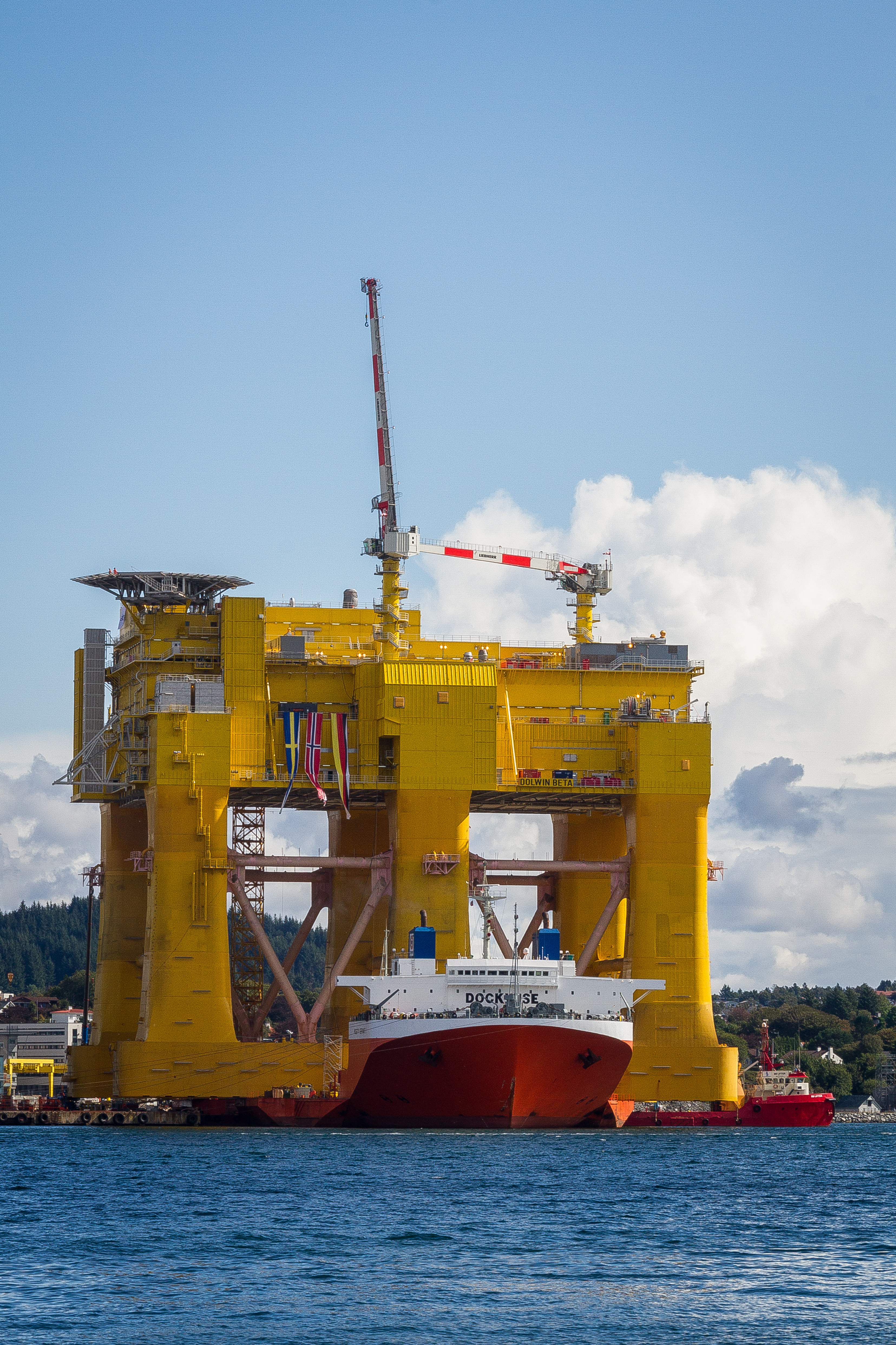 Mighty Servant 1 heavy-lift ship transporting DolWin beta offshore HVDC converter platform at Haugesund, Norway. 
Not that it is such a great shot in its own right, but I just had to take a picture of this! It is right outside my doorstep. Viewed from my house on the Karmøy island towards east and the city of Haugesund.

No - I am not playing with perspective or anything here. That ship (Mighty Servant 1) IS actually carrying this huge structure. The project is a cooperation between Aibel Norway and ABB. The structure itself has been built in Dubai, and is now at the Aibel yard in Haugesund for final equipment installations and testing. It has a capacity of 900 MW and will receive power from 240 wind turbines in the North Sea from Q2 2015.