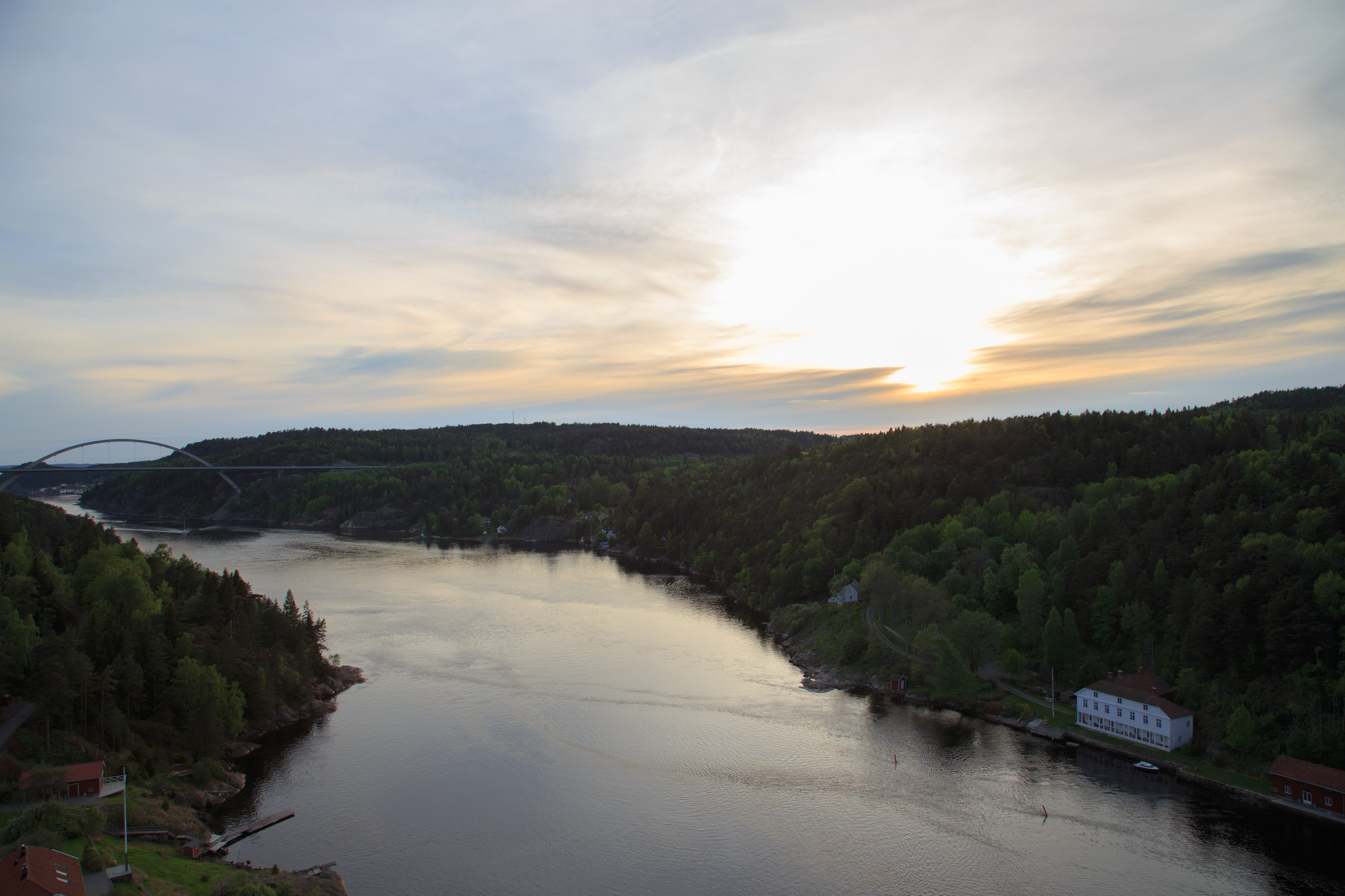 This shot was taken from the old Svinesund bridge, heading west. The new Svinesund bridge (completed 2005) can be seen to the far left, the old customs check point / house down on the right. Sweden on the left of the fjord, Norway on the right. The small costal village Sponvika / Sponviken can be seen behind the Svinesund bridge.