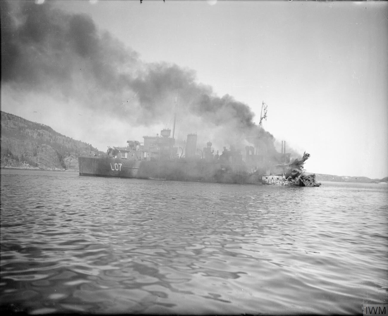 HMS BITTERN ablaze in Namsos Fjord after having suffered a direct hit in the stern by an aerial bomb during the evacuation of Namsos.