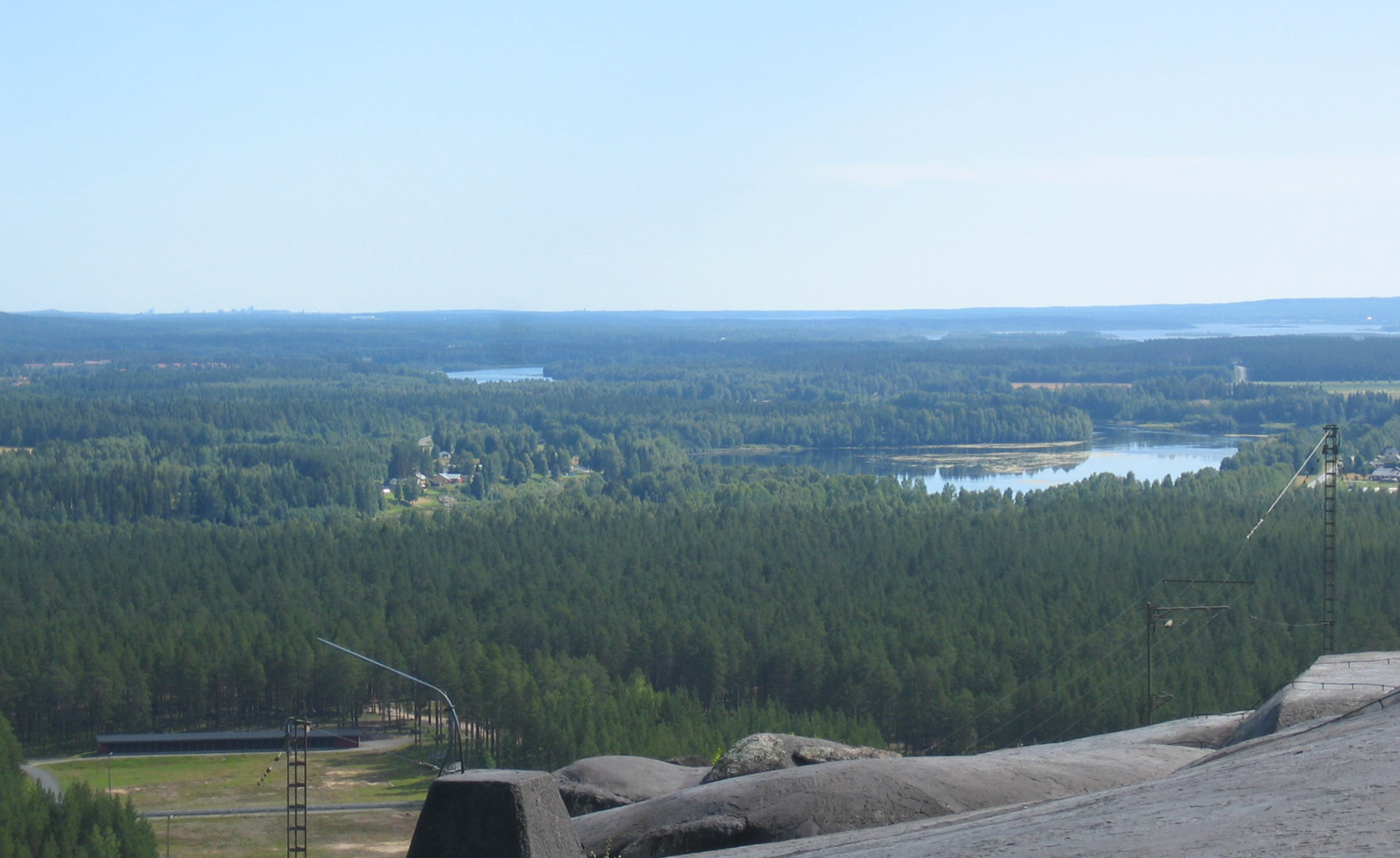 The view if looking southwest from Rödberget fort, part of Boden Fortress. A shooting range and Lule river are clearly visible, and the silhouettes of buildings to the left in the horizon are industries in Luleå some 30 km away.