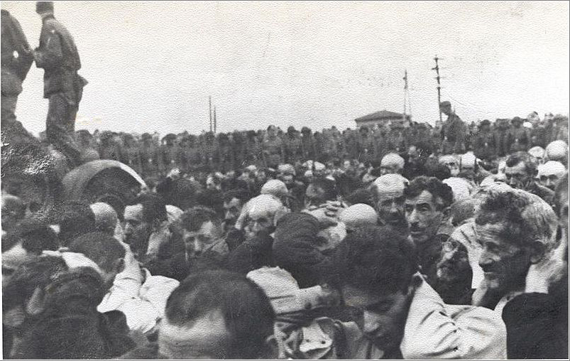 Liquidation of the Białystok Ghetto, 15–20 August 1943. Jewish men with their hands up, watched by a German military unit.
