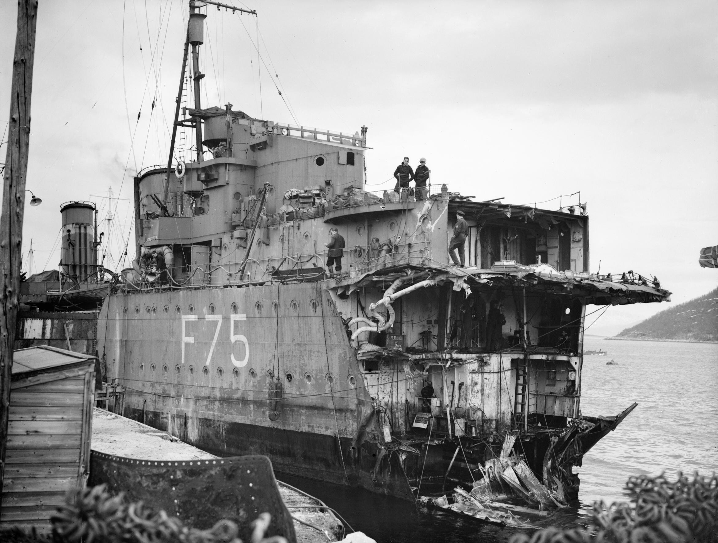 The British destroyer HMS Eskimo (F75), with her bow blown off by a torpedo during the Second Battle of Narvik, docked on the Norwegian coast. Despite this she will be setting off to England for repair in this state.