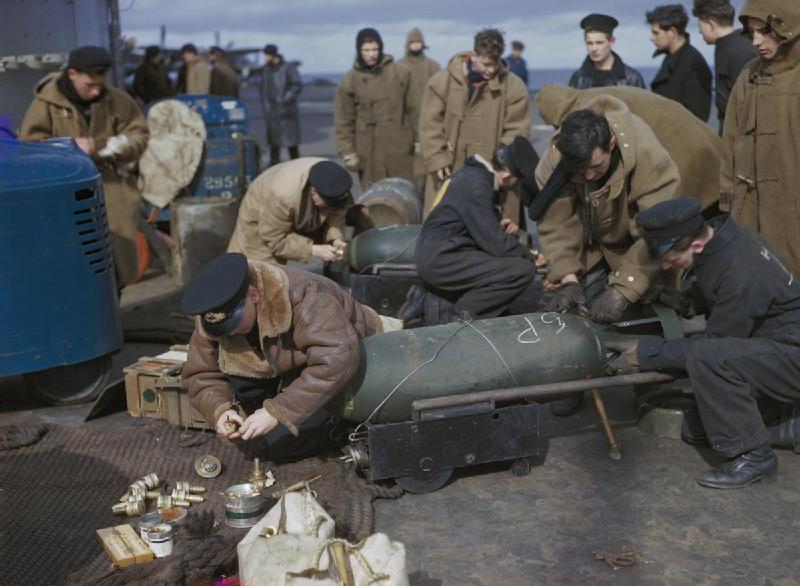 Fleet Air Arm personnel fusing bombs for Fairey Barracudas on the flight deck of HMS VICTORIOUS, before Operation 'Tungsten', the attack on the German battleship TIRPITZ in Alten Fjord, Norway, April 1944.