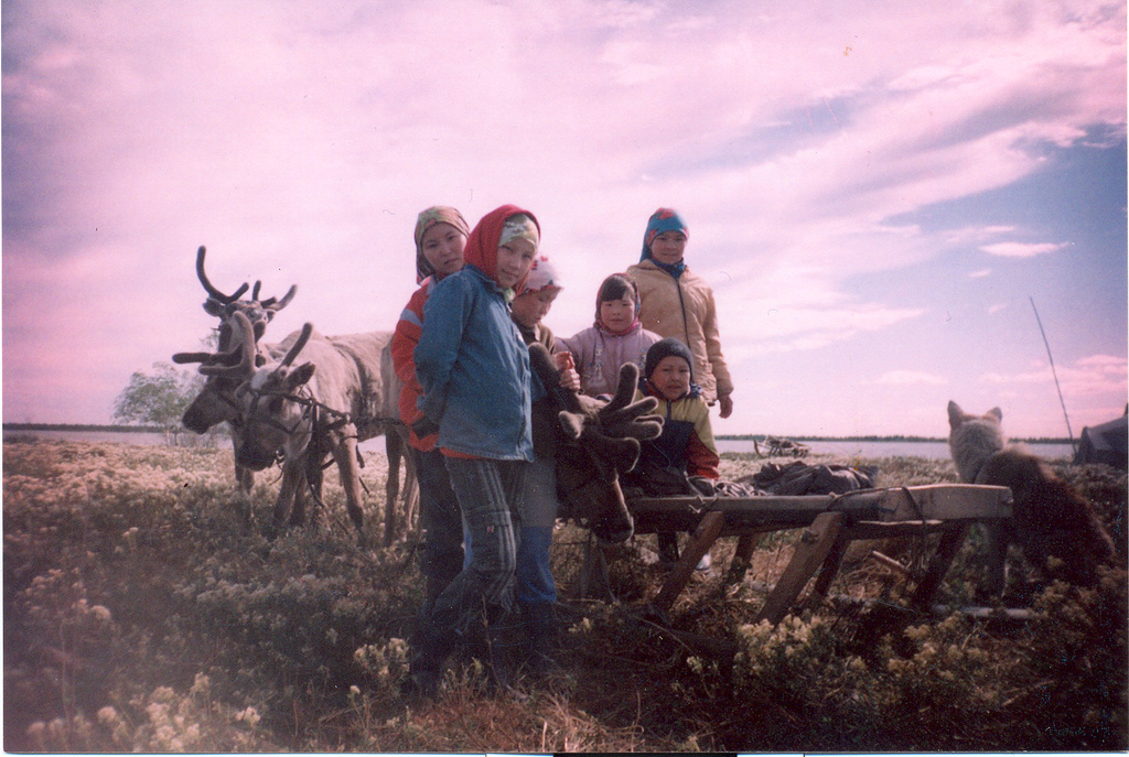 Khanty children pose for the camera in front of a reindeer sledge near Lake Numto, Khantia-Mansia, RussiaReindeers and children