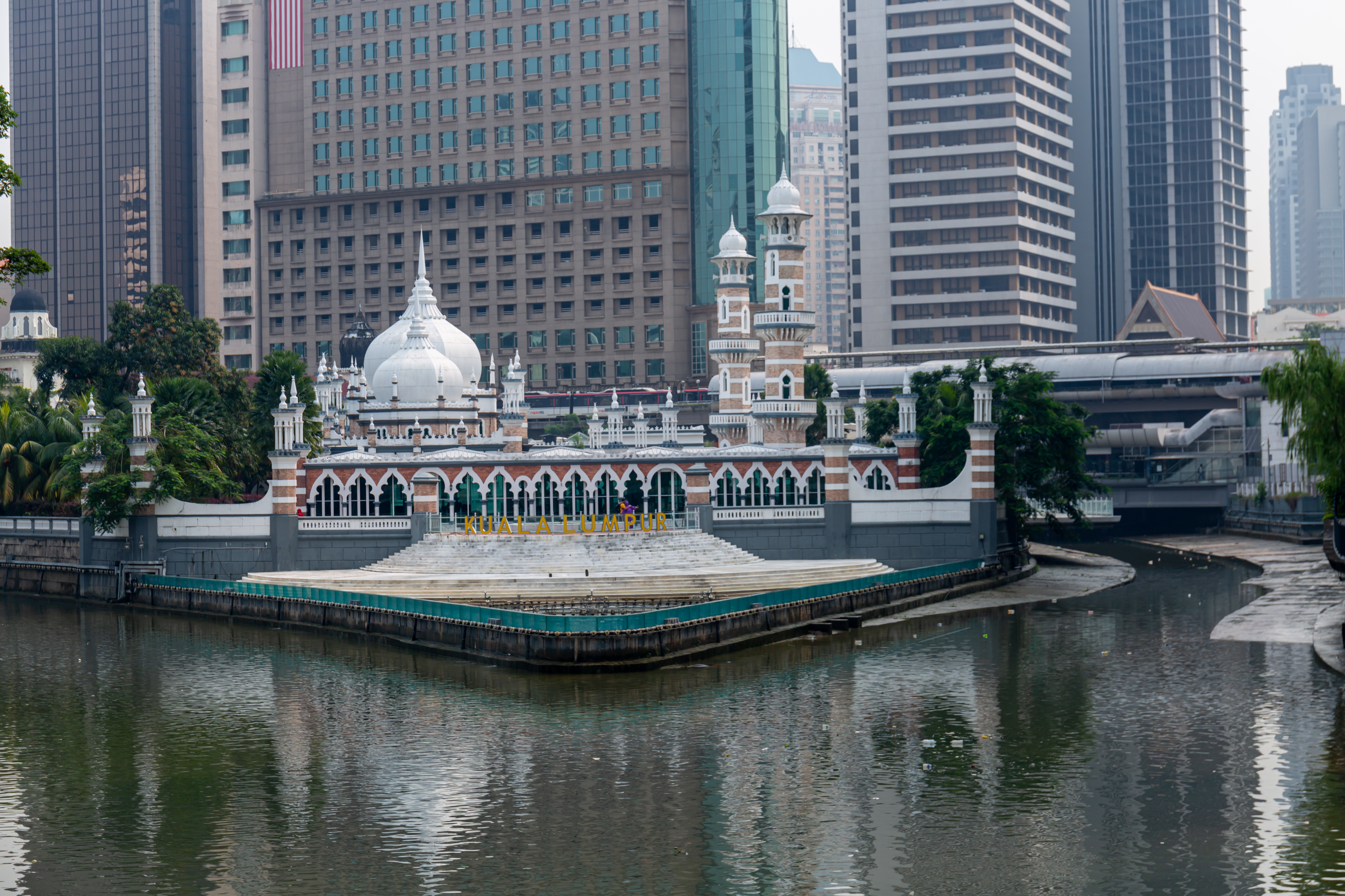 The Sultan Abdul Samad Jamek Mosque and Kolam Biru in Kuala Lumpur, viewed from the bridge to the south along the Klang River.
