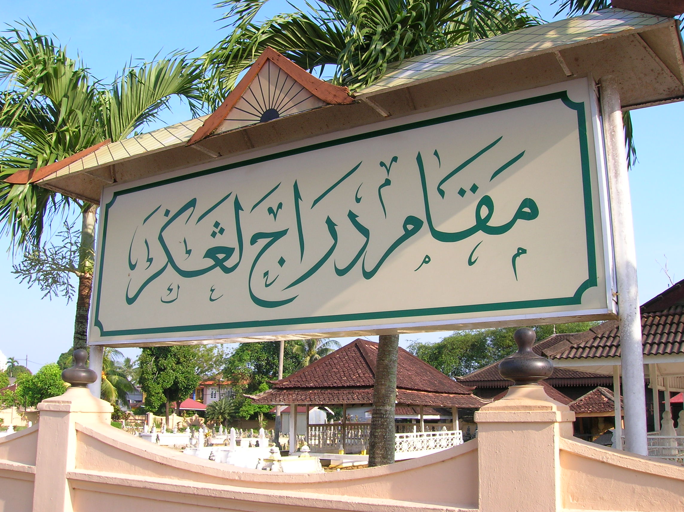 Signboard of the Makam Diraja Langgar located in the state of Kelantan in Malaysia. The signboard uses the Jawi script written in simple Islamic calligraphy.  The Jawi text reads: مقام دراج لڠڬر 
The Jawi script does not use diacritics. Diacritics are used when writing Jawi in Islamic calligraphy style.
