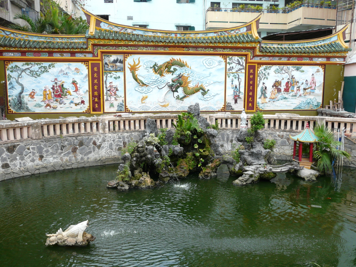This photograph shows the garden across from Quan Am Pagoda in Cho Lon, Ho Chi Minh City, Vietnam.  The motifs on the panels are Taoist.