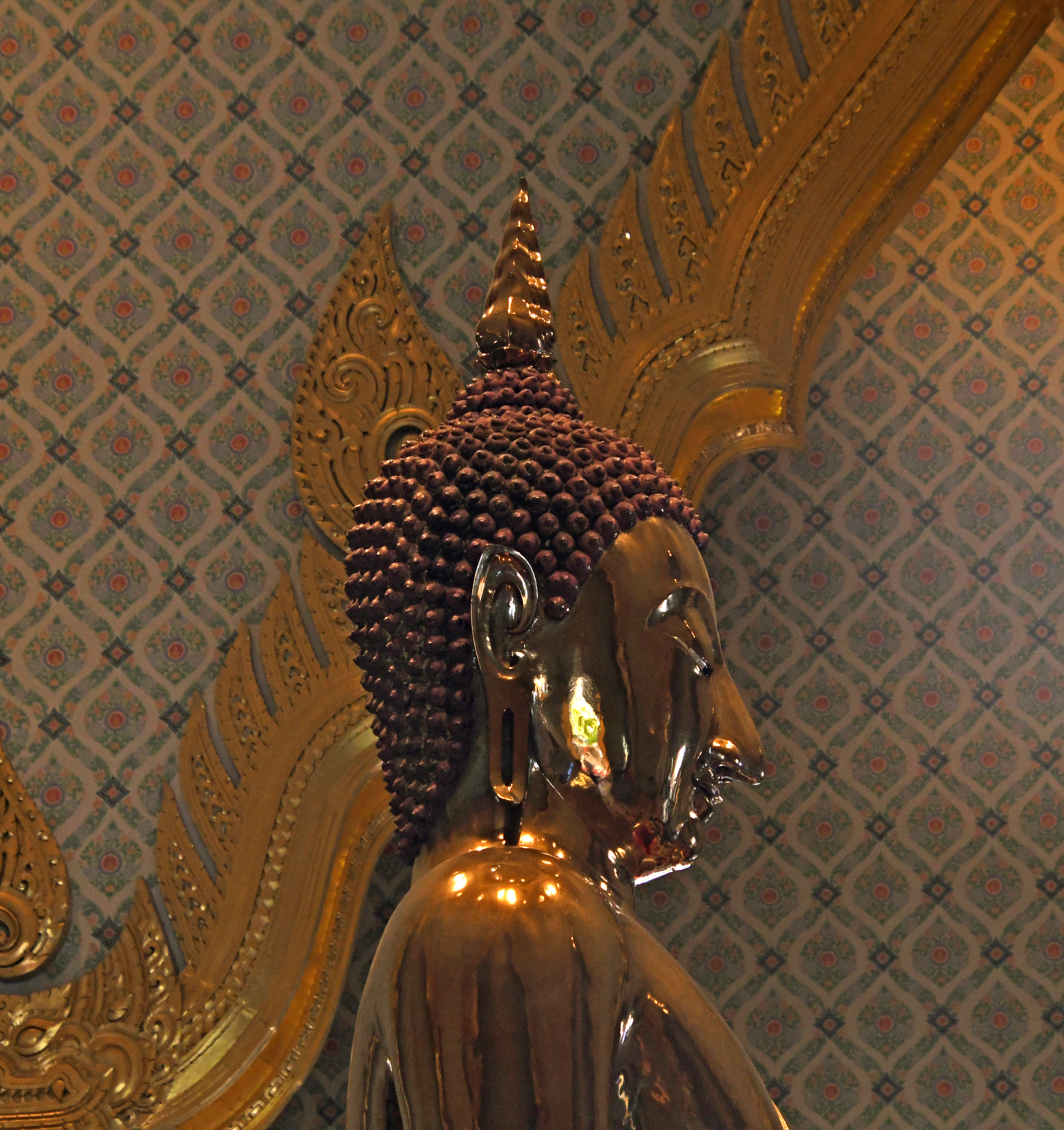 Side view of the golden buddha statue in the temple of Wat Traimit, Bangkok, Thailand.