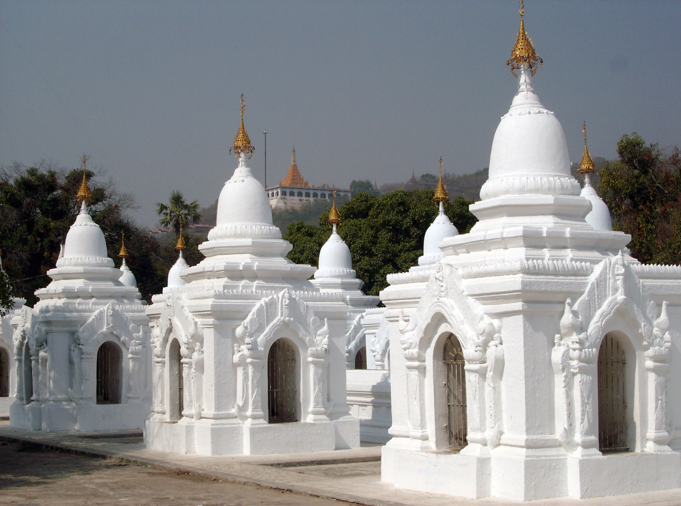 Some of the 729 stupas that house a stone inscription each of the entire en:Tipitaka or en:Theravada en:Buddhist canon and known as the en:world's largest book at the Kuthodaw (Royal Merit) pagoda at the foot of en:Mandalay Hill