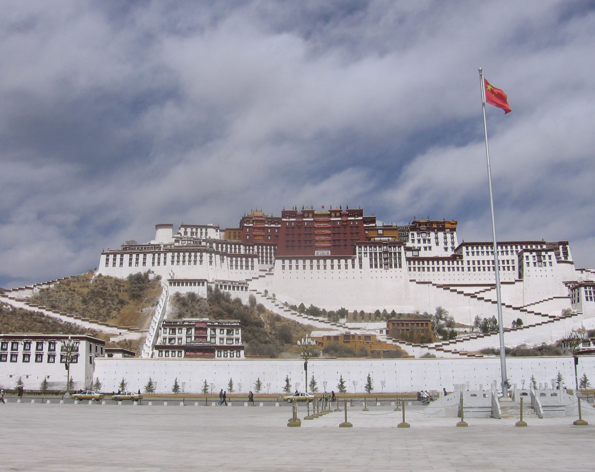 Lhasa's Potala Palace, seen from the public square built by the Chinese across from it, PRC flag flying against the blue sky.
