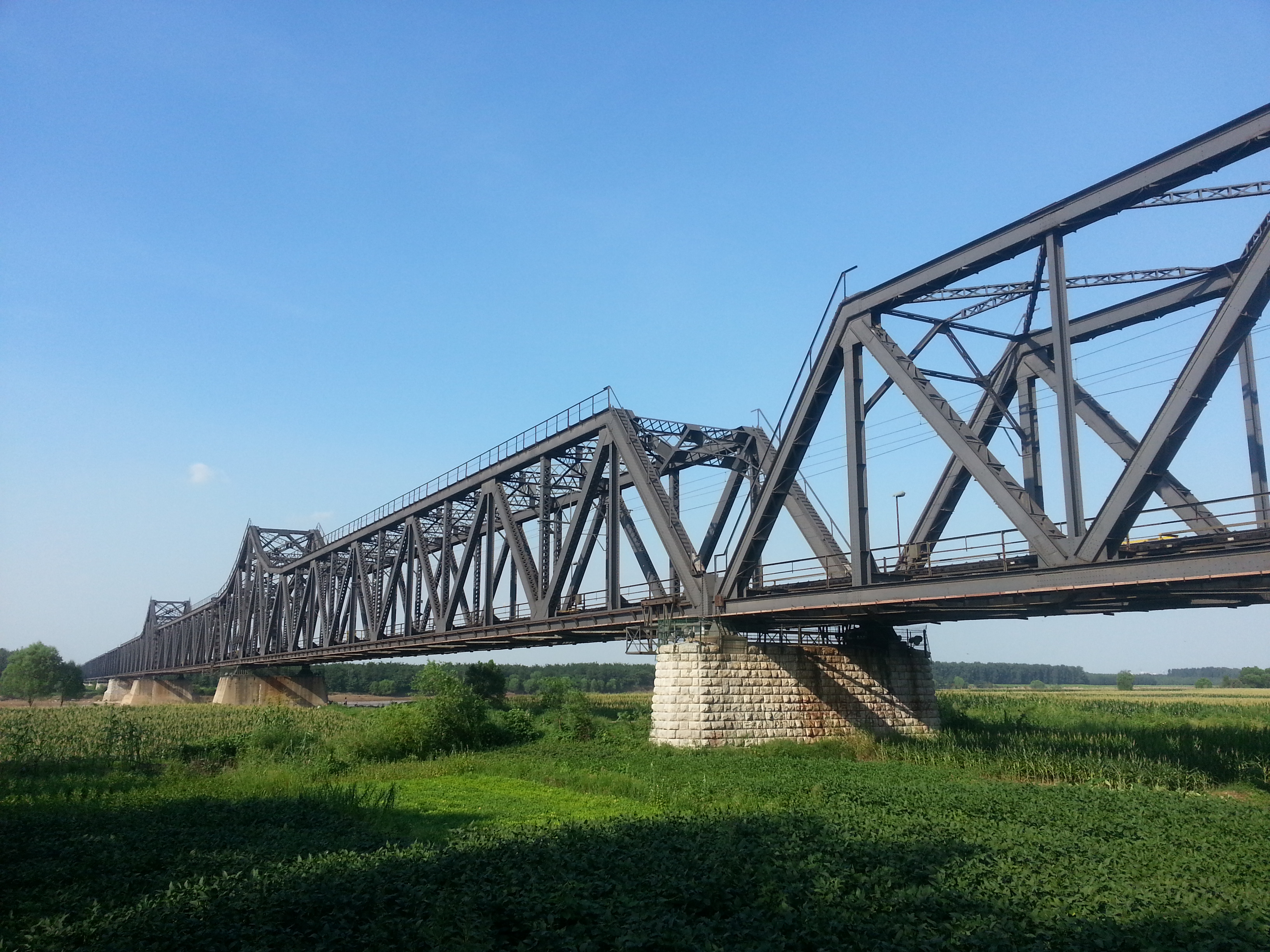 Photograph of the Luokou Yellow River railway bridge in Jinan, Shandong, China. Close-up view from the southern bank of the Yellow River.
