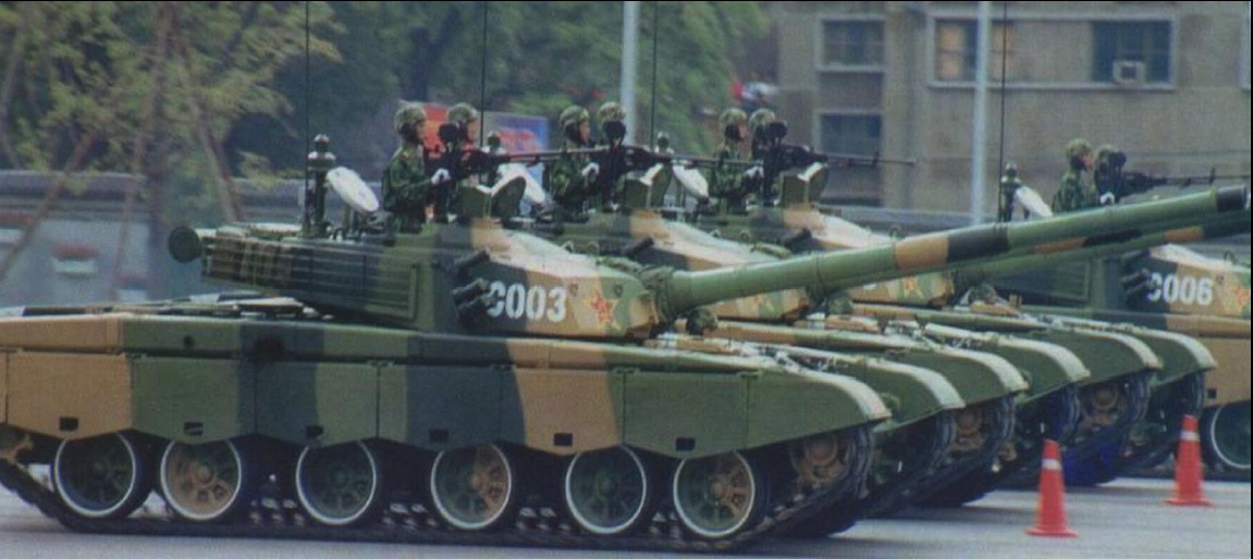 Caption: "Chinese Type 98
MBTs on parade in
Beijing in October.
Note new hull
skirts, rubber padded
tracks, and the

raised turret roof."