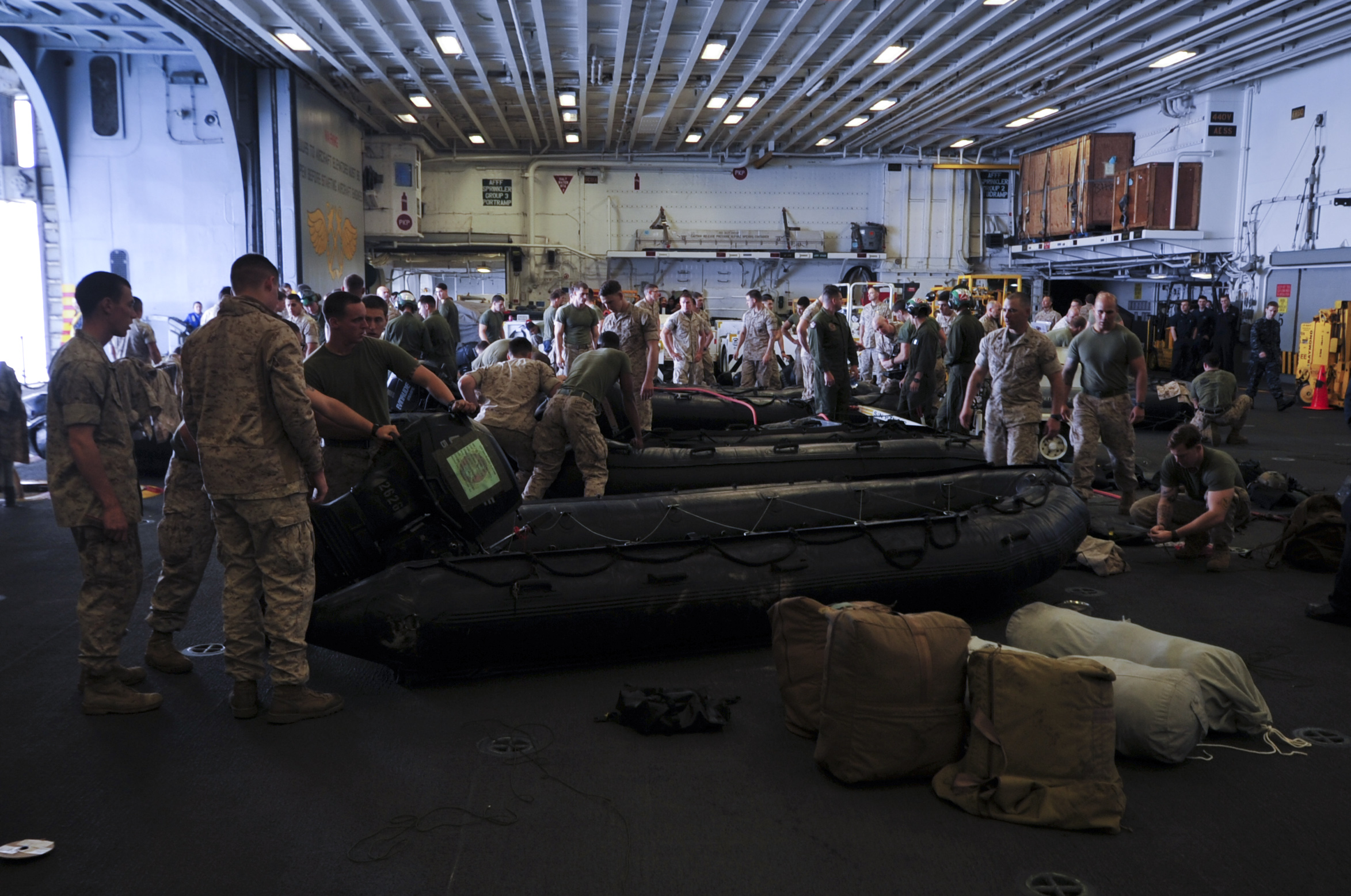 Marines assigned to the 31st Marine Expeditionary Unit prepare combat rubber raiding crafts (CRRC) in the hangar bay of the forward-deployed amphibious assault ship USS Bonhomme Richard (LHD 6). Bonhomme Richard is responding to the scene of Korean passenger ship Sewol that sank near the island of Jindo off the southwestern coast of the Republic of Korea April 16. (U.S. Navy photo by Mass Communication Specialist 2nd Class Adam D. Wainwright/Released)