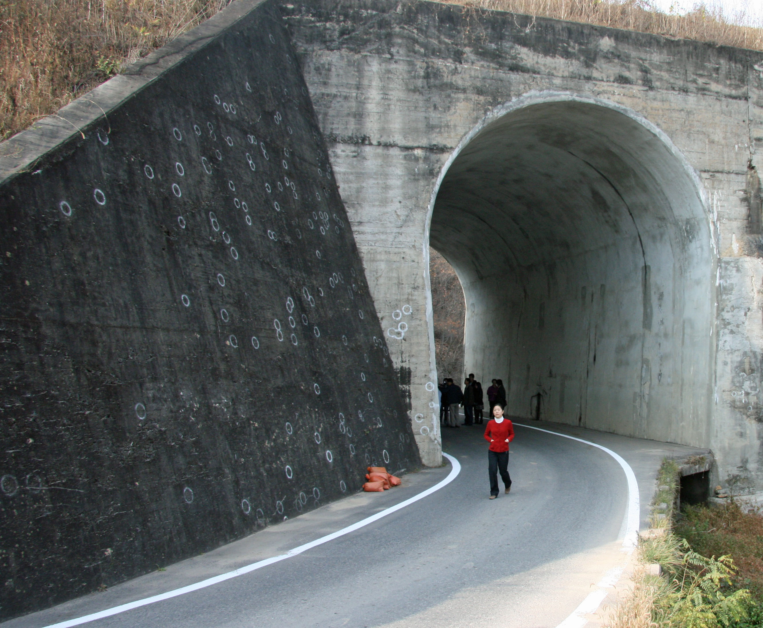 This 2008 photo shows a concrete abutment outside one of the twin underpasses of the No Gun Ri railroad bridge, where investigators' white paint identifies bullet marks and embedded fragments from U.S. Army gunfire in the 1950 massacre of South Korean refugees trapped beneath the bridge. Others are similarly marked inside the tunnel. Still other evidence lies beneath the level of the road, built years after the killings.