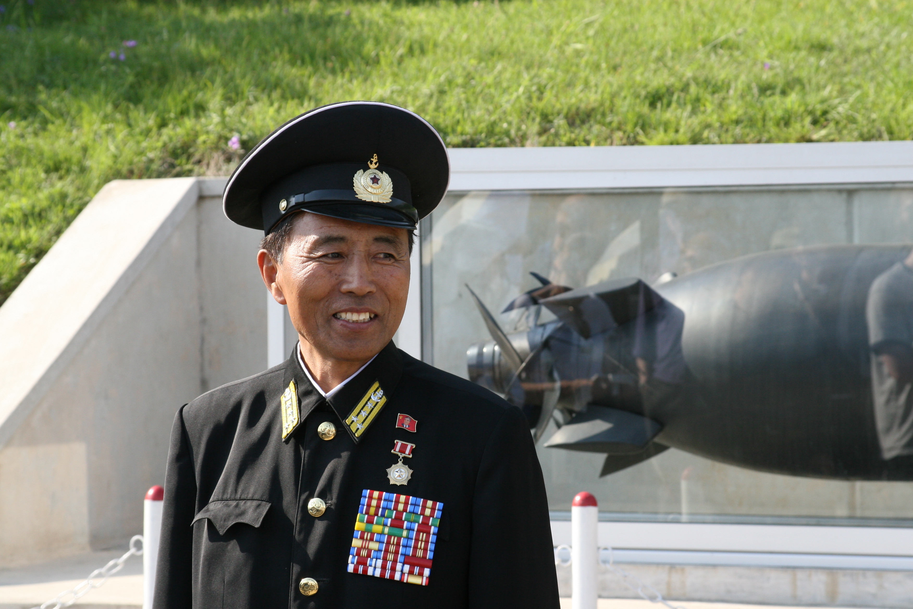 A North Korean guide (naval Senior Colonel) next to the USS Pueblo
